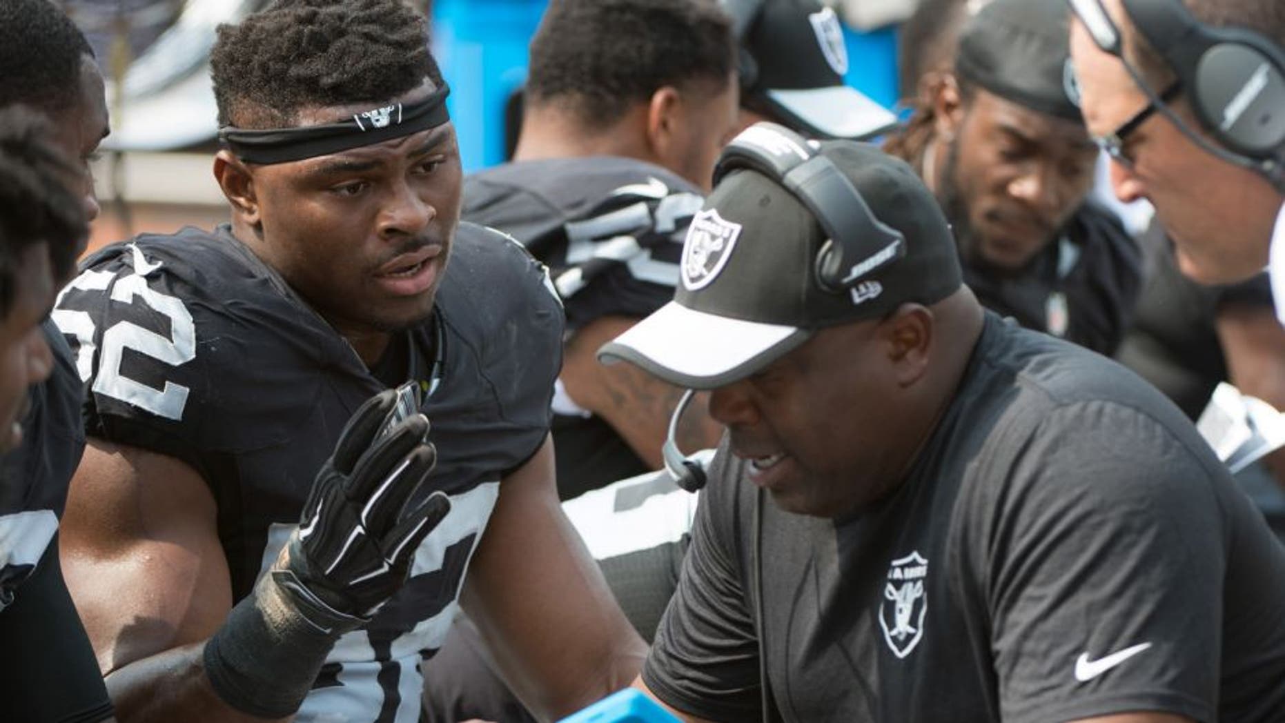September 13, 2015; Oakland, CA, USA; Oakland Raiders defensive end Khalil Mack (52) talks to defensive line coach Jethro Franklin (right) during the second quarter against the Cincinnati Bengals at O.co Coliseum. The Bengals defeated the Raiders 33-13. Mandatory Credit: Kyle Terada-USA TODAY Sports