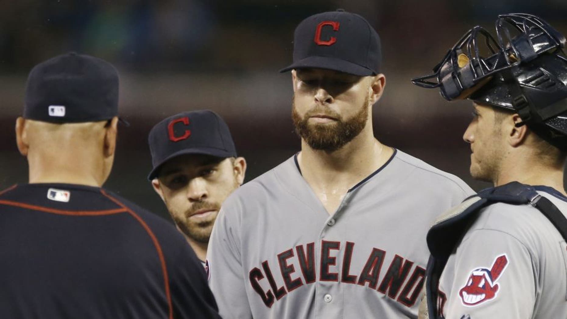 Cleveland Indians pitcher Corey Kluber, center, hands over the ball to manager Terry Francona as he is pulled after giving up four runs to the Minnesota Twins in the fourth inning of a baseball game, Wednesday, Sept. 23, 2015, in Minneapolis.