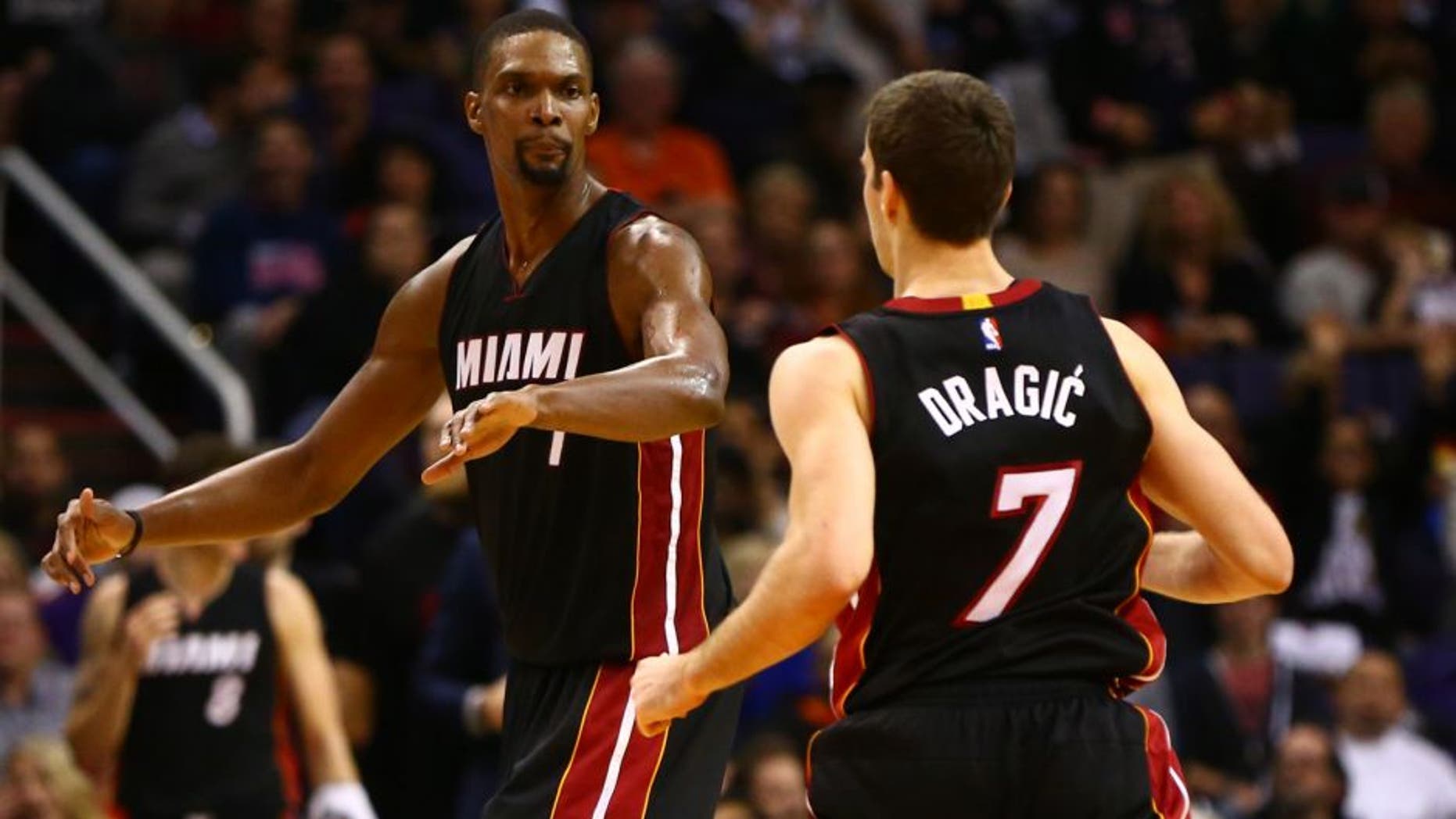 Jan 8, 2016; Phoenix, AZ, USA; Miami Heat center Chris Bosh (1) celebrates a play with guard Goran Dragic (7) against the Phoenix Suns at Talking Stick Resort Arena. The Heat defeated the Suns 103-95. Mandatory Credit: Mark J. Rebilas-USA TODAY Sports