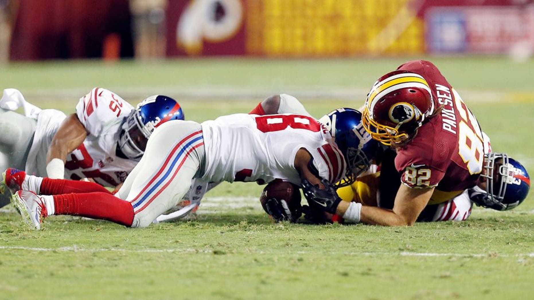 Sep 25, 2014; Landover, MD, USA; New York Giants cornerback Trumaine McBride (38) recovers a fumble by Washington Redskins tight end Logan Paulsen (82) in the second quarter at FedEx Field. Mandatory Credit: Geoff Burke-USA TODAY Sports