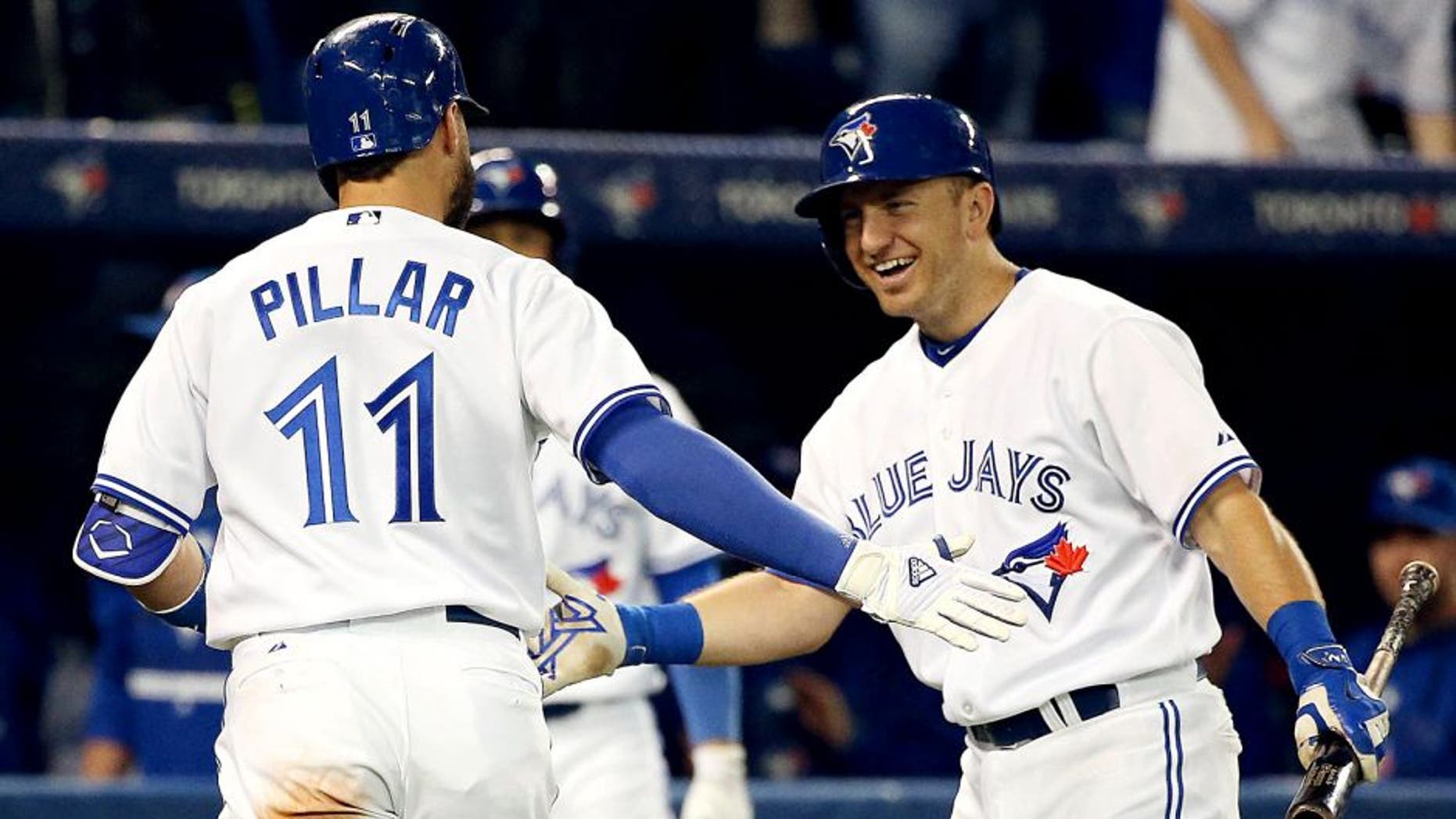 TORONTO, ON- SEPTEMBER 25 - Cliff Pennington congratulates Kevin Pillar after a home run in the fourth inning as the Toronto Blue Jays open a three game series against the Tampa Bay Rays at Rogers Centre in Toronto. September 25, 2015. (Steve Russell/Toronto Star via Getty Images)