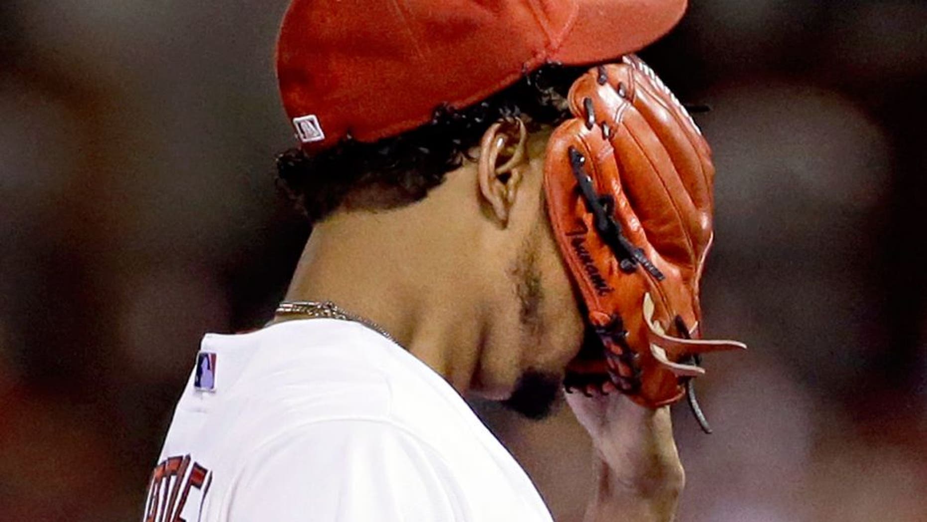 St. Louis Cardinals starting pitcher Carlos Martinez covers his face as he leaves the field during the first inning of a baseball game against the Milwaukee Brewers on Friday, Sept. 25, 2015, in St. Louis. Martinez was removed with an apparent injury after throwing seven pitches. (AP Photo/Jeff Roberson)