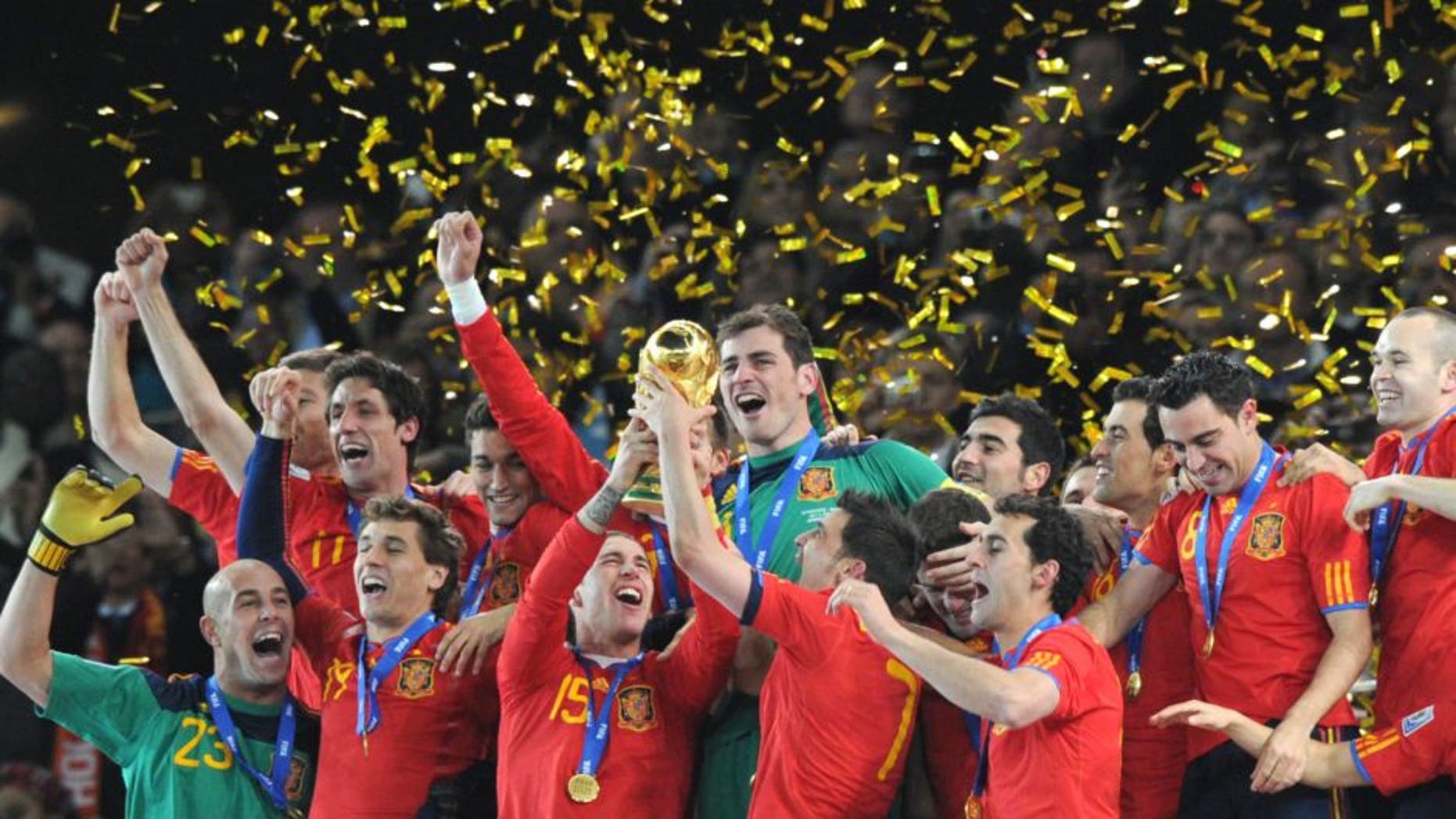 Spain's defender Sergio Ramos (C, L) and Spain's striker David Villa (C, R) hold the trophy as Spain's national football team players celebrate winning the 2010 World Cup football final Netherlands vs. Spain on July 11, 2010 at Soccer City stadium in Soweto, suburban Johannesburg. NO PUSH TO MOBILE / MOBILE USE SOLELY WITHIN EDITORIAL ARTICLE - AFP PHOTO / PEDRO UGARTE (Photo credit should read PEDRO UGARTE/AFP/Getty Images)