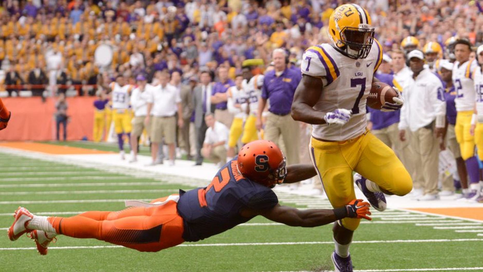 Sep 26, 2015; Syracuse, NY, USA; LSU Tigers running back Leonard Fournette (7) scores a touchdown after braking a tackle by Syracuse Orange cornerback Wayne Morgan (2) during the first quarter in a game at the Carrier Dome. Mandatory Credit: Mark Konezny-USA TODAY Sports