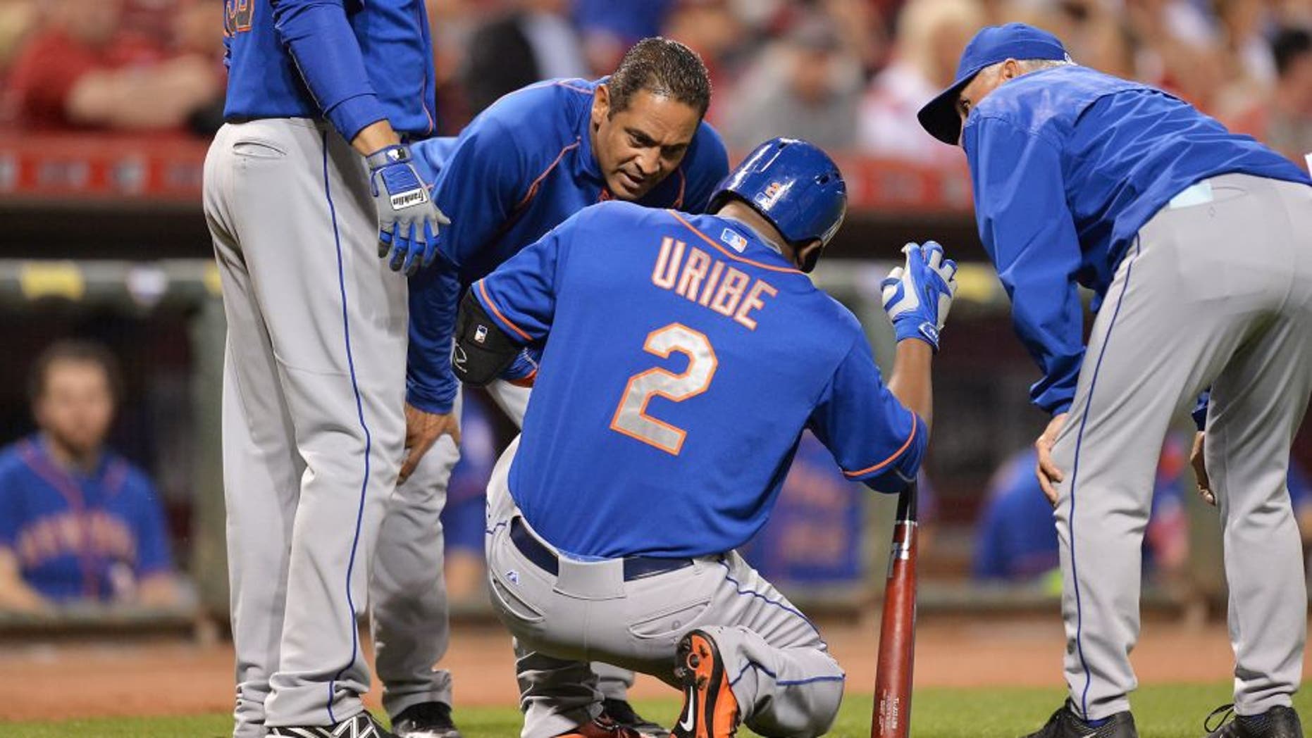 CINCINNATI, OH - SEPTEMBER 25: Juan Uribe #2 of the New York Mets is attended to by Mets personnel after injuring himself while batting against the Cincinnati Reds in the eighth inning at Great American Ball Park on September 25, 2015 in Cincinnati, Ohio. New York defeated Cincinnati 12-5. (Photo by Jamie Sabau/Getty Images)