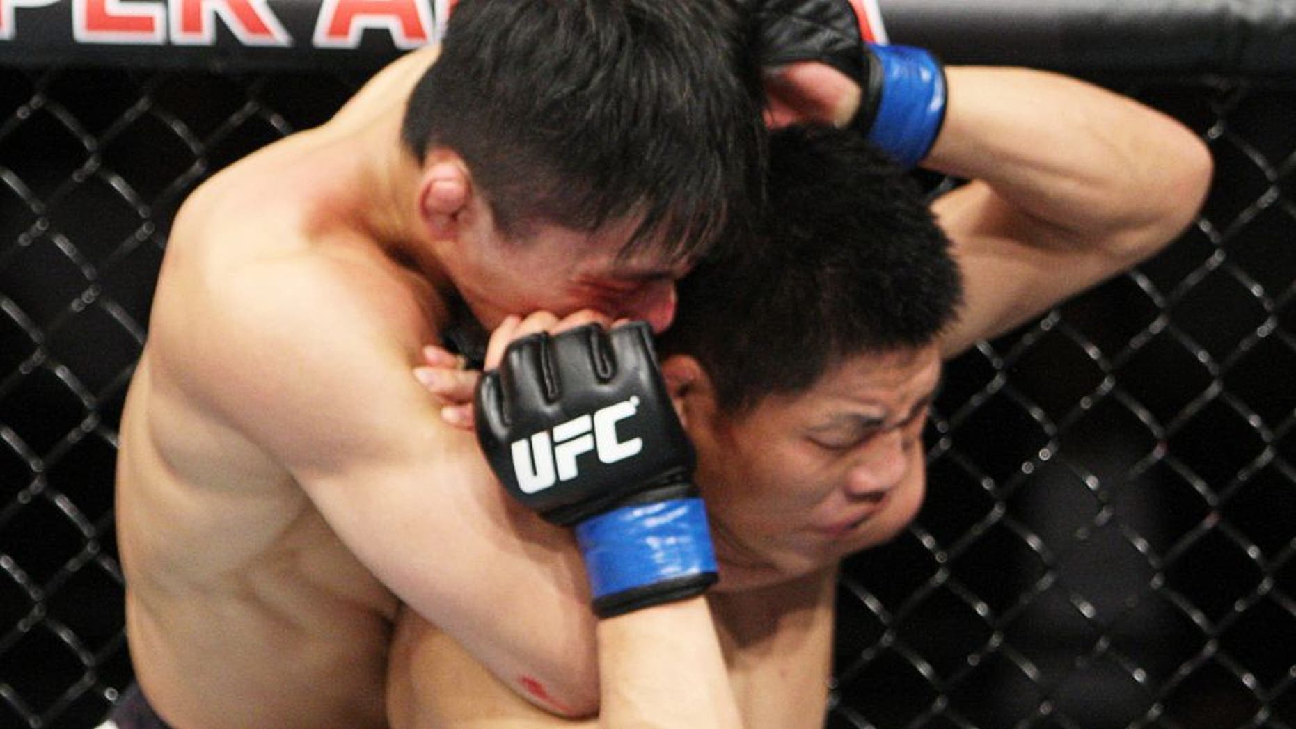 SAITAMA, JAPAN - SEPTEMBER 27: Keita Nakamura of Japan locks in a a rear naked choke on Li Jingliang of China in their welterweight bout during the UFC event at the Saitama Super Arena on September 27, 2015 in Saitama, Japan. (Photo by Mitch Viquez/Zuffa LLC/Zuffa LLC via Getty Images)
