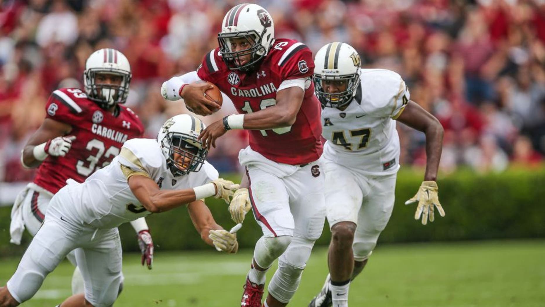 Sep 26, 2015; Columbia, SC, USA; South Carolina Gamecocks quarterback Lorenzo Nunez (19) eludes UCF Knights defensive back Tre Neal (33) and defensive back Jerod Boykin (47) during the second quarter at Williams-Brice Stadium. Mandatory Credit: Jim Dedmon-USA TODAY Sports