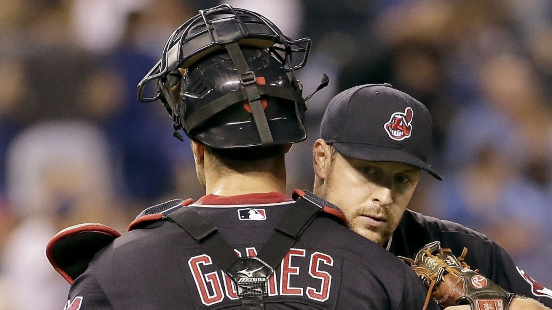 Cleveland Indians relief pitcher Bryan Shaw hugs catcher Yan Gomes after their baseball game against the Kansas City Royals Saturday, Sept. 26, 2015, in Kansas City, Mo. The Indians won 9-5.