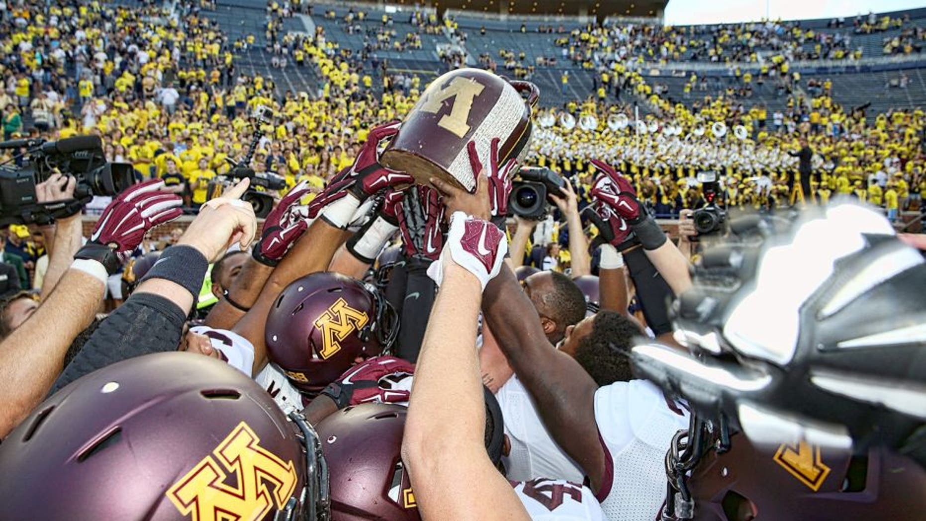 ANN ARBOR, MI - SEPTEMBER 27: Members of the Minnesota Golden Gophers football team celebrate a win over the Michigan Wolverines with the Little Brown Jug and the fans a Michigan Stadium on September 27, 2014 in Ann Arbor, Michigan. The Golden Gophers defeated the Wolvereines 30-14. (Photo by Leon Halip/Getty Images)