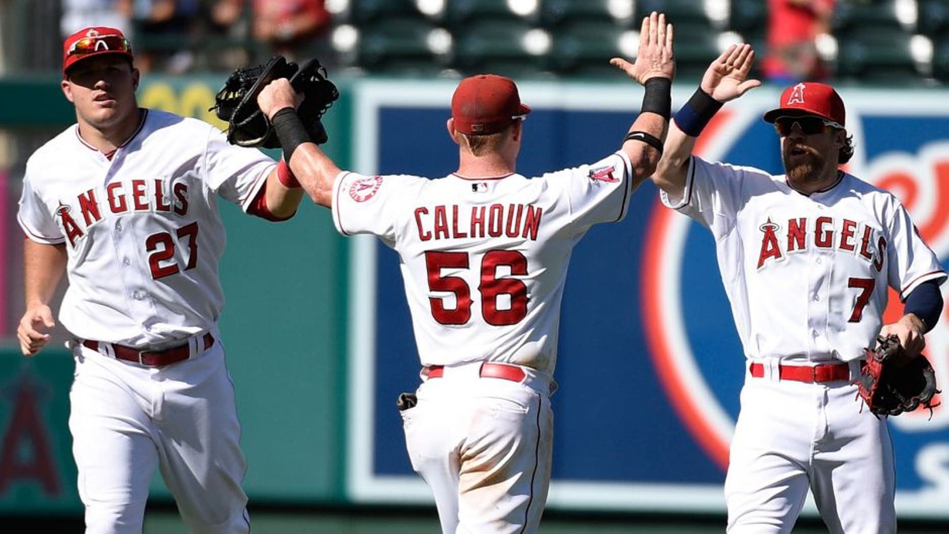 Sep 27, 2015; Anaheim, CA, USA; Los Angeles Angels center fielder Mike Trout (27) and right fielder Kole Calhoun (56) and left fielder Collin Cowgill (right) celebrate after the game against the Seattle Mariners during the ninth inning at Angel Stadium of Anaheim. The Angels won 3-2. Mandatory Credit: Kelvin Kuo-USA TODAY Sports