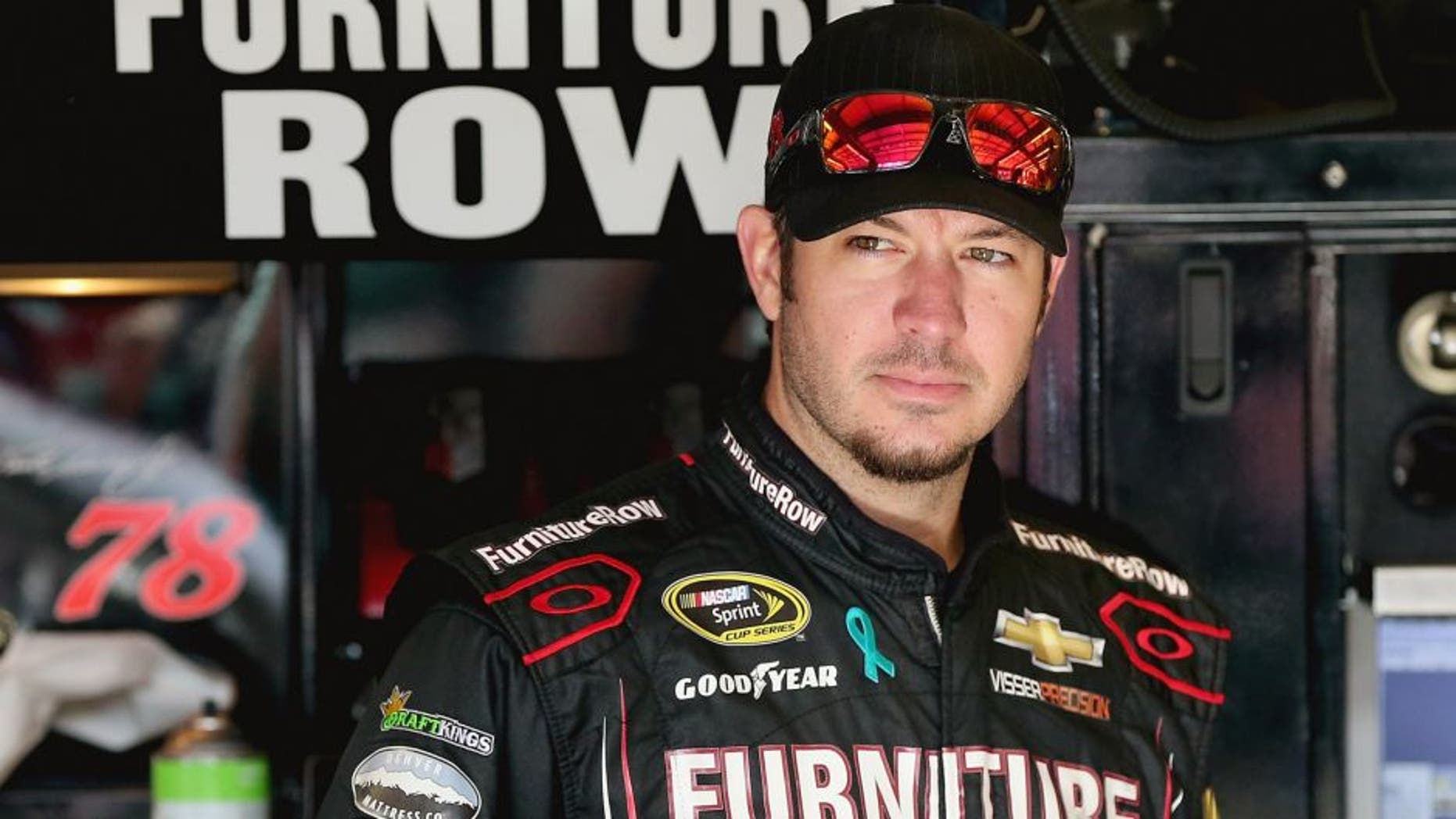 Martin Truex Jr, driver of the #78 Furniture Row/Visser Precision Chevrolet, stands in the garage area during practice for the NASCAR Sprint Cup Series MyAFibRisk.com 400 at Chicagoland Speedway on September 19, 2015 in Joliet, Illinois. (Photo by Jonathan Daniel/Getty Images)