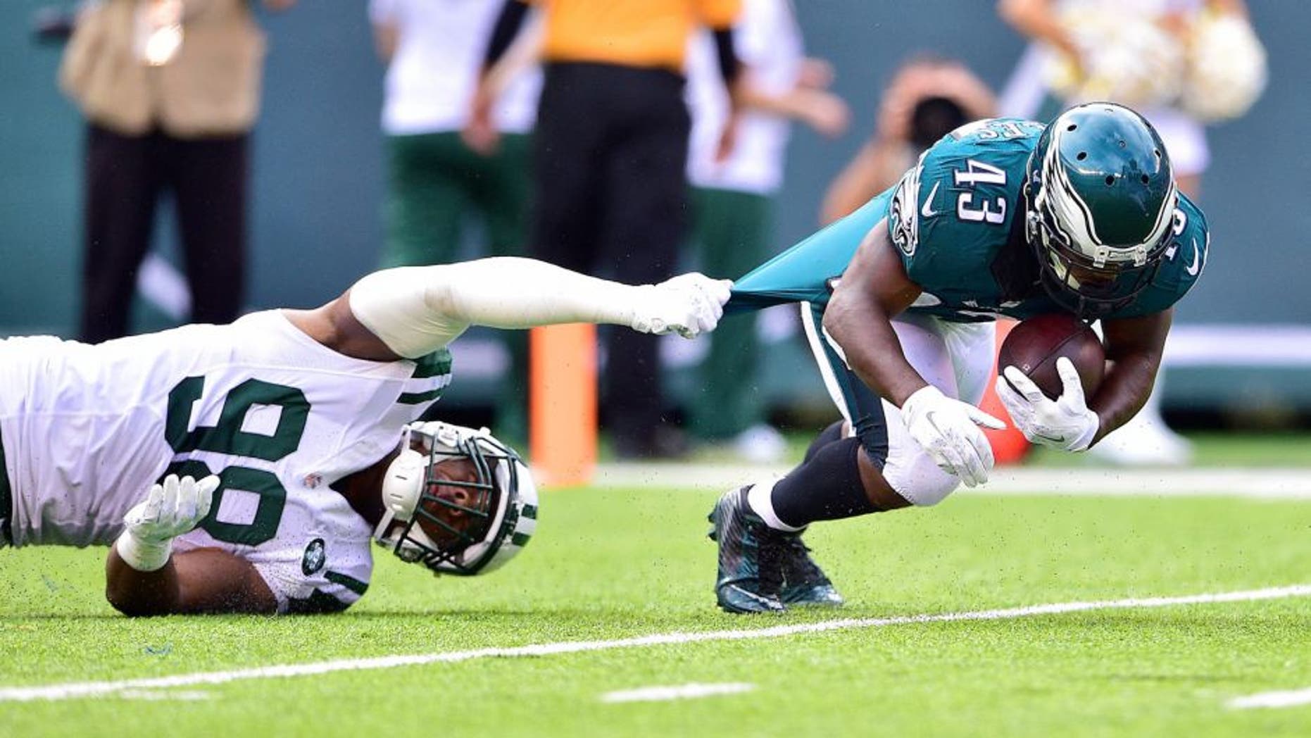 Sep 27, 2015; East Rutherford, NJ, USA; Philadelphia Eagles running back Darren Sproles (43) is taken down by New York Jets outside linebacker Quinton Coples (98) in the first half at MetLife Stadium. Mandatory Credit: Steven Ryan-USA TODAY Sports