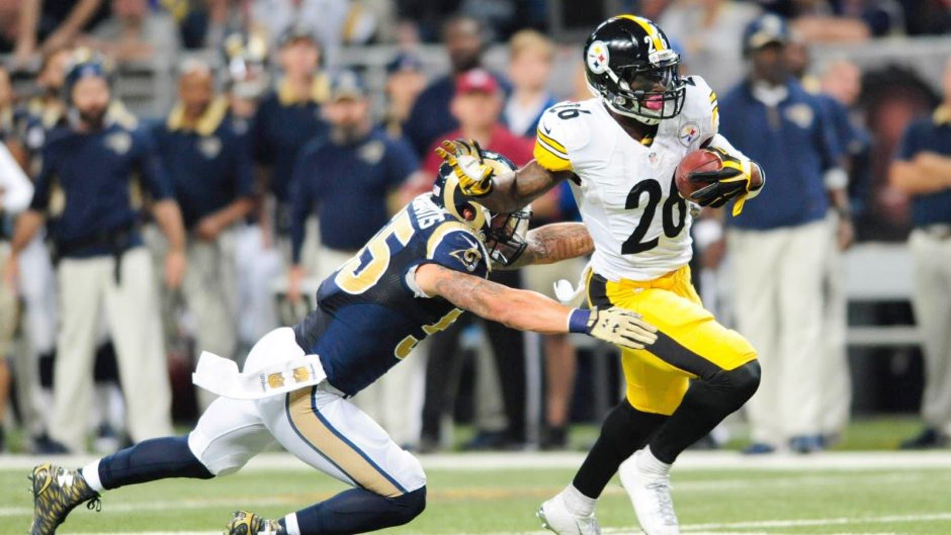 Sep 27, 2015; St. Louis, MO, USA; Pittsburgh Steelers running back Le'Veon Bell (26) carries the ball away from St. Louis Rams middle linebacker James Laurinaitis (55) during the first half at The Edward Jones Dome. Mandatory Credit: Joshua Lindsey-USA TODAY Sports