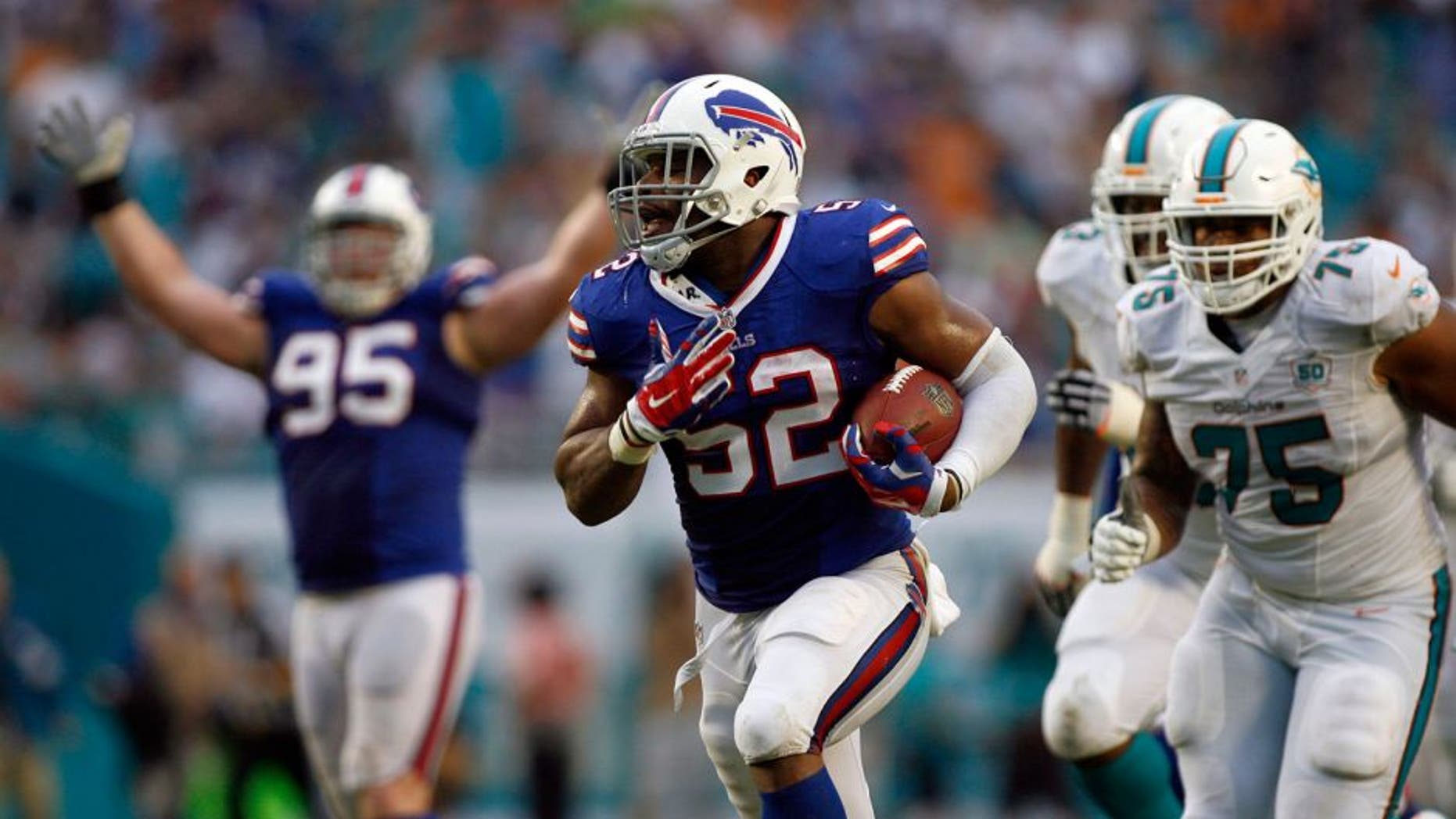 Sep 27, 2015; Miami Gardens, FL, USA; Preston Brown (52) runs to score with this interception as Miami Dolphins guard Jamil Douglas (75) chases in the 2nd quarter at Sun Life Stadium. Mandatory Credit: Andrew Innerarity-USA TODAY Sports