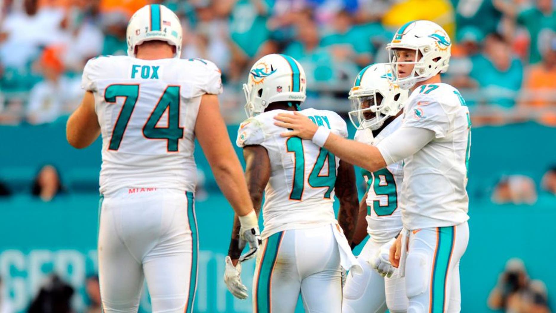 Sep 27, 2015; Miami Gardens, FL, USA; Miami Dolphins quarterback Ryan Tannehill (right) checks on Dolphins wide receiver Jarvis Landry (center) after a play during the first half against the Buffalo Bills at Sun Life Stadium. Mandatory Credit: Steve Mitchell-USA TODAY Sports