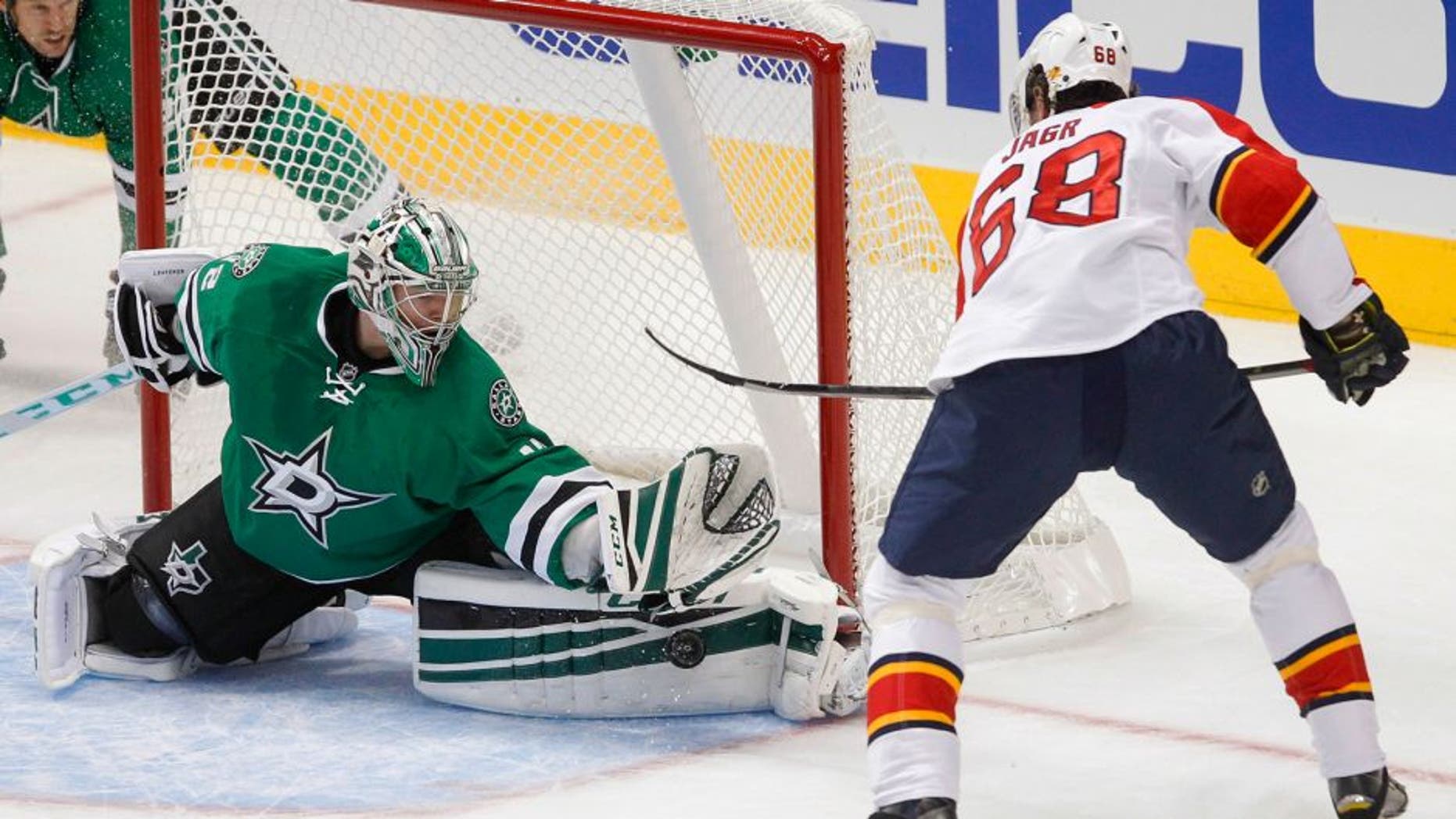 Dallas Stars goalie Kari Lehtonen, left, reaches out to stop the shot from Florida Panthers right wing Jaromir Jagr (44) during the first period of an NHL preseason hockey game Sunday, Sept. 27, 2015, in Dallas. (AP Photo/Tim Sharp)