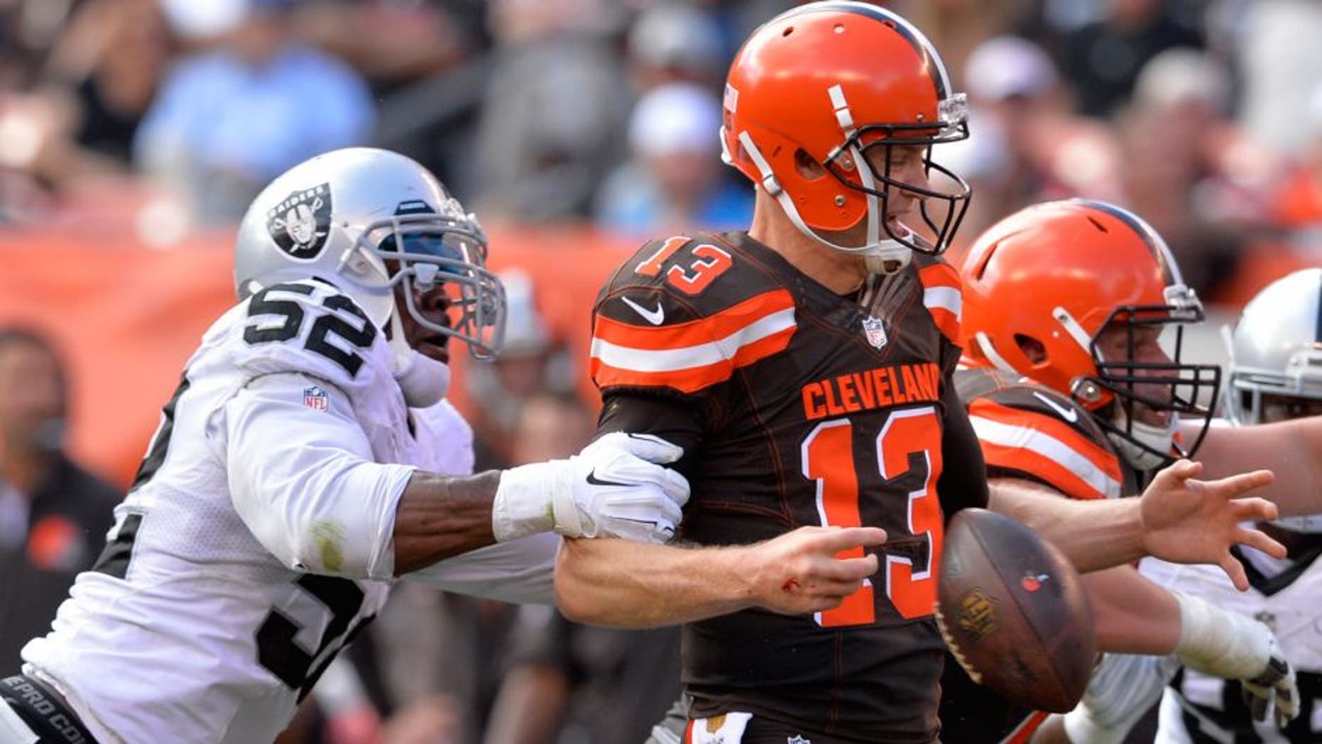 Oakland Raiders defensive end Khalil Mack (52) hits Cleveland Browns quarterback Josh McCown (13) causing a fumble in the second half of an NFL football game, Sunday, Sept. 27, 2015, in Cleveland. The Raiders recovered the fumble. (AP Photo/David Richard)