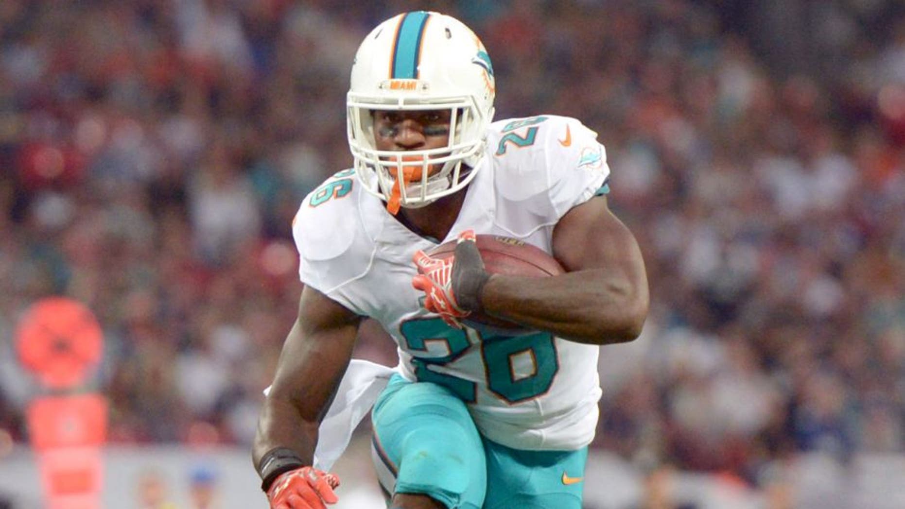 Sep 28, 2014; London, UNITED KINGDOM; Miami Dolphins running back Lamar Miller (26) scores on a 9-yard touchdown run in the second quarter against the Oakland Raiders in the NFL International Series game at Wembley Stadium. Mandatory Credit: Kirby Lee-USA TODAY Sports