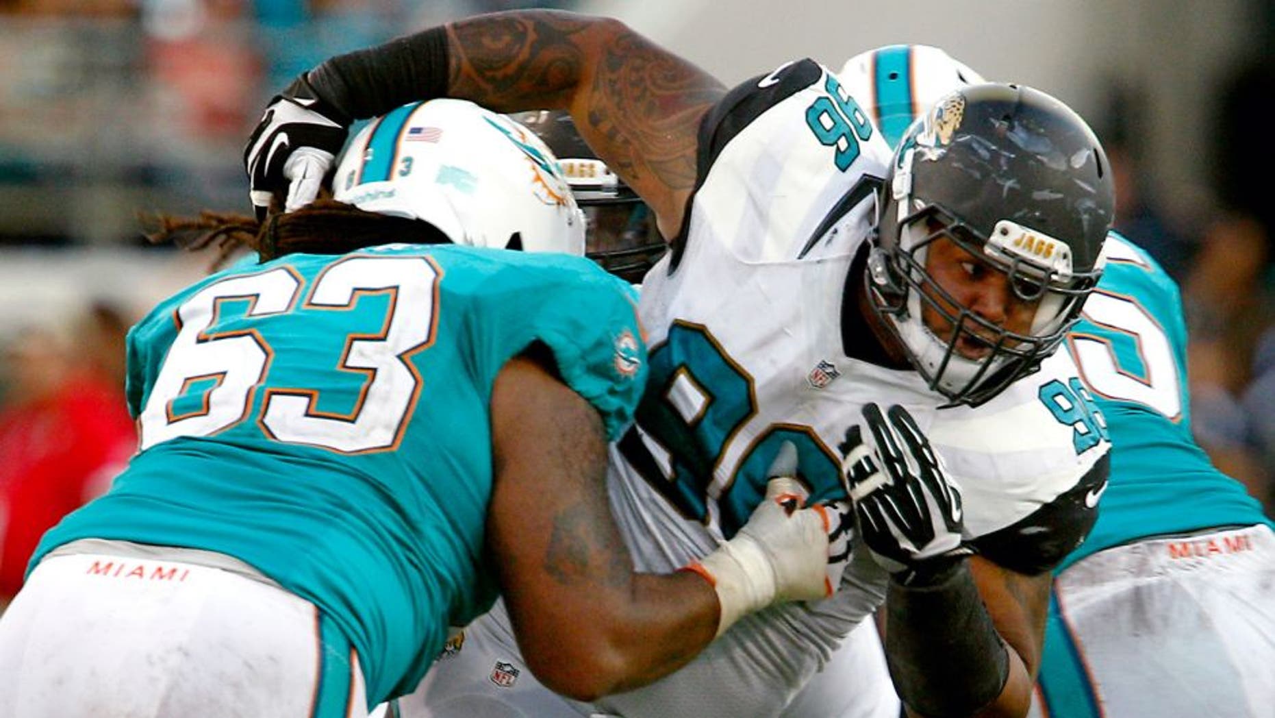 Sep 20, 2015; Jacksonville, FL, USA; Jacksonville Jaguars defensive tackle Michael Bennett (96) is held by Miami Dolphins offensive guard Dallas Thomas (63) during the second half of an NFL Football game at EverBank Field. The Jacksonville Jaguars won 23-20. Mandatory Credit: Reinhold Matay-USA TODAY Sports