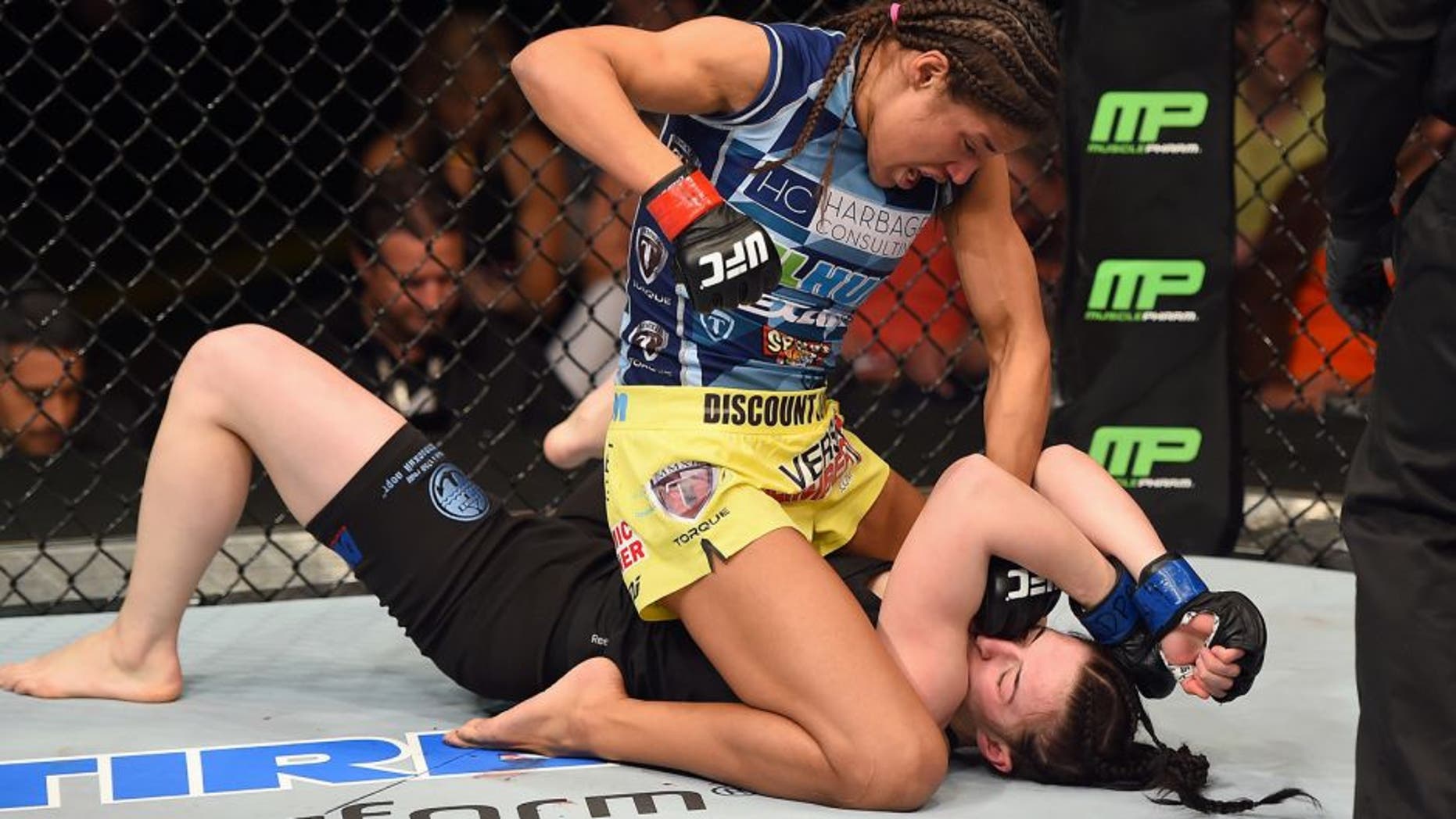 FAIRFAX, VA - APRIL 04: (L-R) Juliana Pena punches Milana Dudieva on the ground in their women's bantamweight fight during the UFC Fight Night event at the Patriot Center on April 4, 2015 in Fairfax, Virginia. (Photo by Josh Hedges/Zuffa LLC/Zuffa LLC via Getty Images)