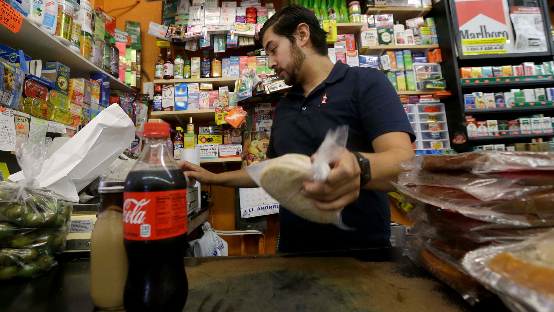 Sept. 21, 2016: Alex Del Rio works behind the counter at his family's market El Ahorro in San Francisco