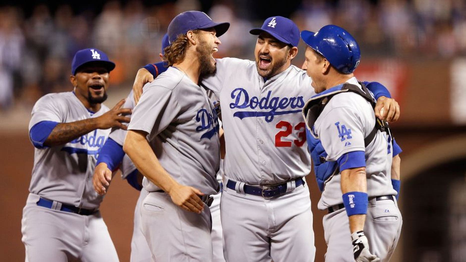 SAN FRANCISCO, CA - SEPTEMBER 29: (L-R) Clayton Kershaw #22, Adrian Gonzalez #23 and A.J. Ellis #17 of the Los Angeles Dodgers celebrate after they beat the San Francisco Giants to clinch the National League West title at AT&T Park on September 29, 2015 in San Francisco, California. (Photo by Ezra Shaw/Getty Images)