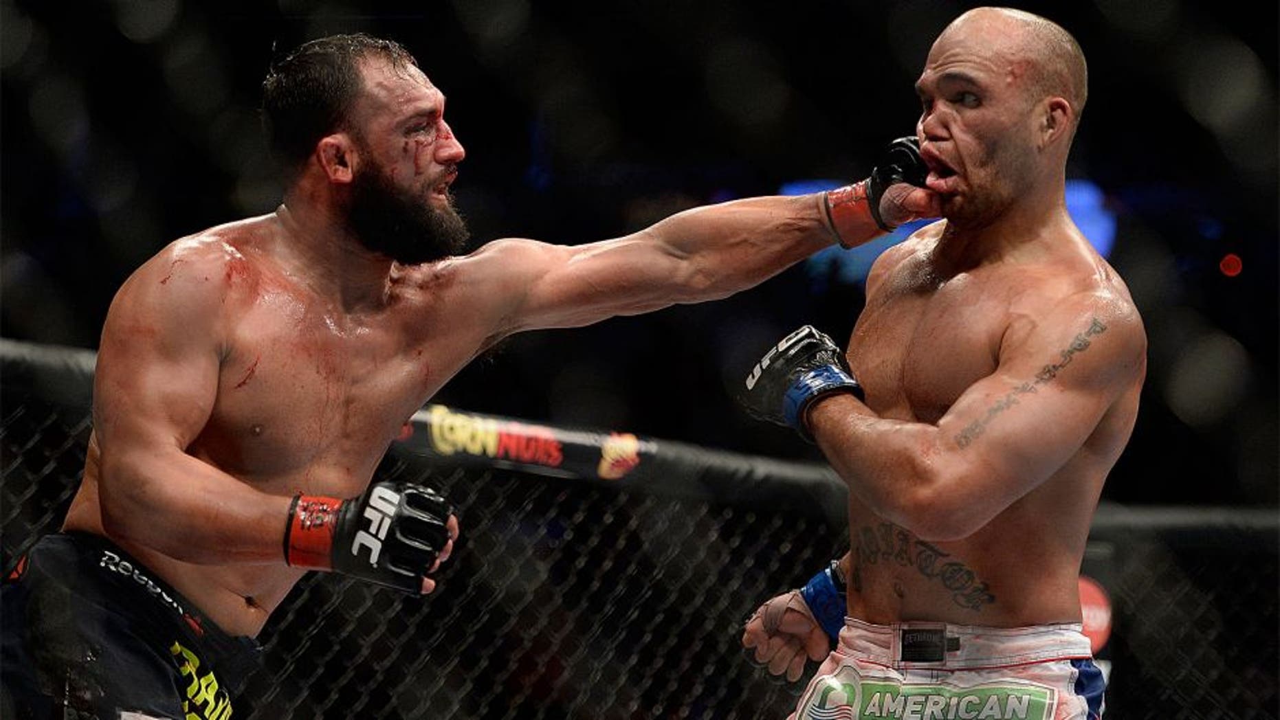 DALLAS, TX - MARCH 15: (L-R) Johny Hendricks punches Robbie Lawler in their welterweight championship fight during the UFC 171 event inside American Airlines Center on March 15, 2014 in Dallas, Texas. (Photo by Jeff Bottari/Zuffa LLC/Zuffa LLC via Getty Images)