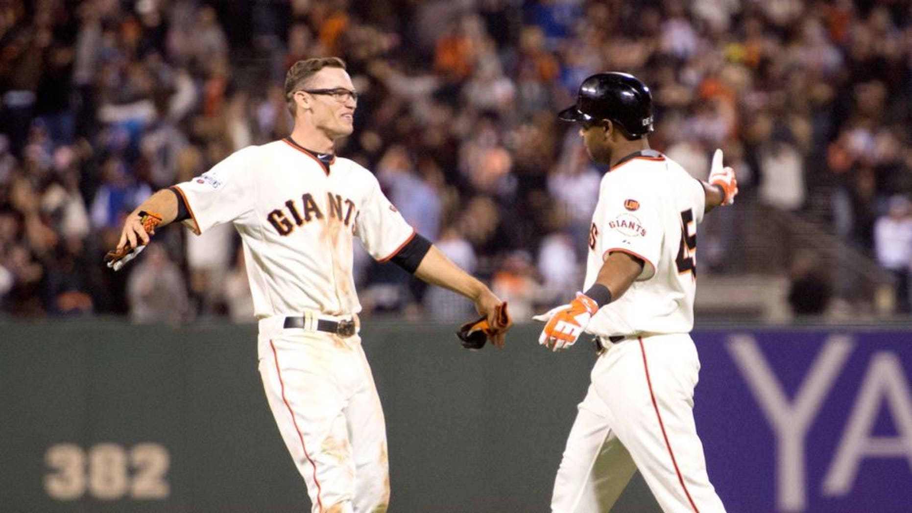 September 28, 2015; San Francisco, CA, USA; San Francisco Giants second baseman Kelby Tomlinson (37, left) congratulates pinch hitter Alejandro De Aza (45, right) for hitting the game-winning sacrifice fly during the 12th inning against the Los Angeles Dodgers at AT&T Park. The Giants defeated the Dodgers 3-2 in 12 innings. Mandatory Credit: Kyle Terada-USA TODAY Sports