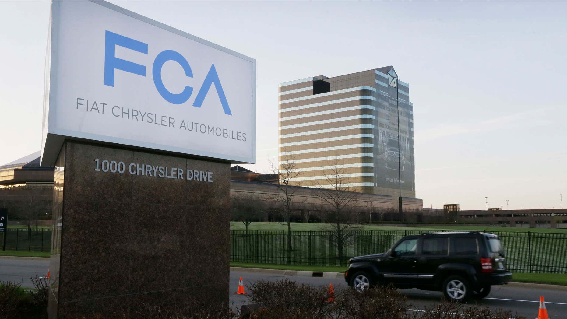 FILE - In this Tuesday, May 6, 2014, file photo, a vehicle moves past a sign outside Fiat Chrysler Automobiles world headquarters in Auburn Hills, Mich.