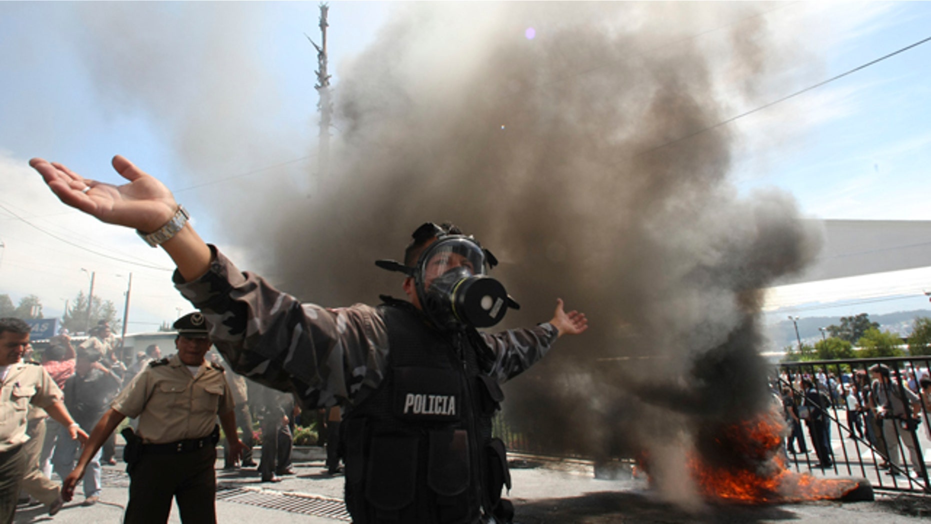 Sept. 30: A police officer demonstrates next to a bonfire during a protest of police officers and soldiers against a new law that cuts their benefits at a police base in Quito, Ecuador.