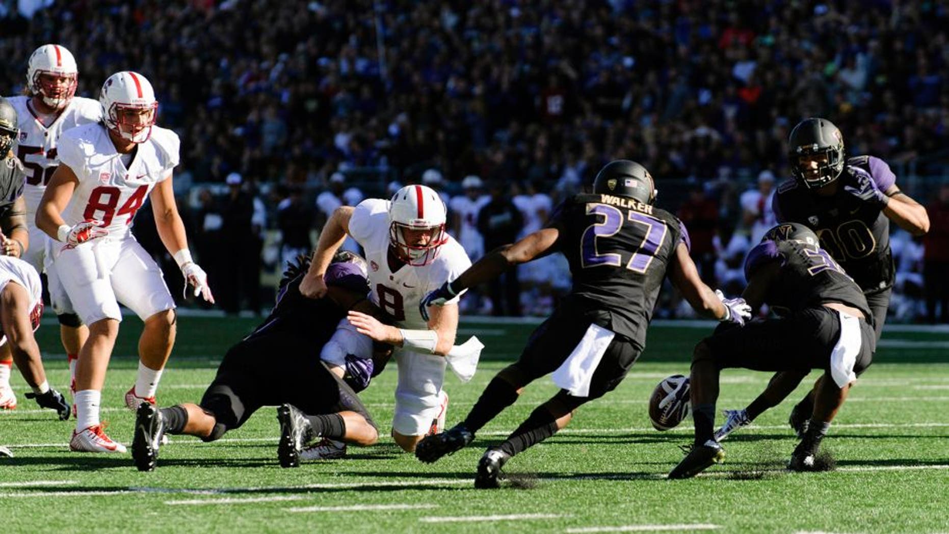Sep 27, 2014; Seattle, WA, USA; Washington Huskies defensive back Budda Baker (32) reaches for the fumbled ball by Stanford Cardinal safety Jordan Richards (8) during the second half at Husky Stadium. Stanford defeated Washington 20-13. Mandatory Credit: Steven Bisig-USA TODAY Sports