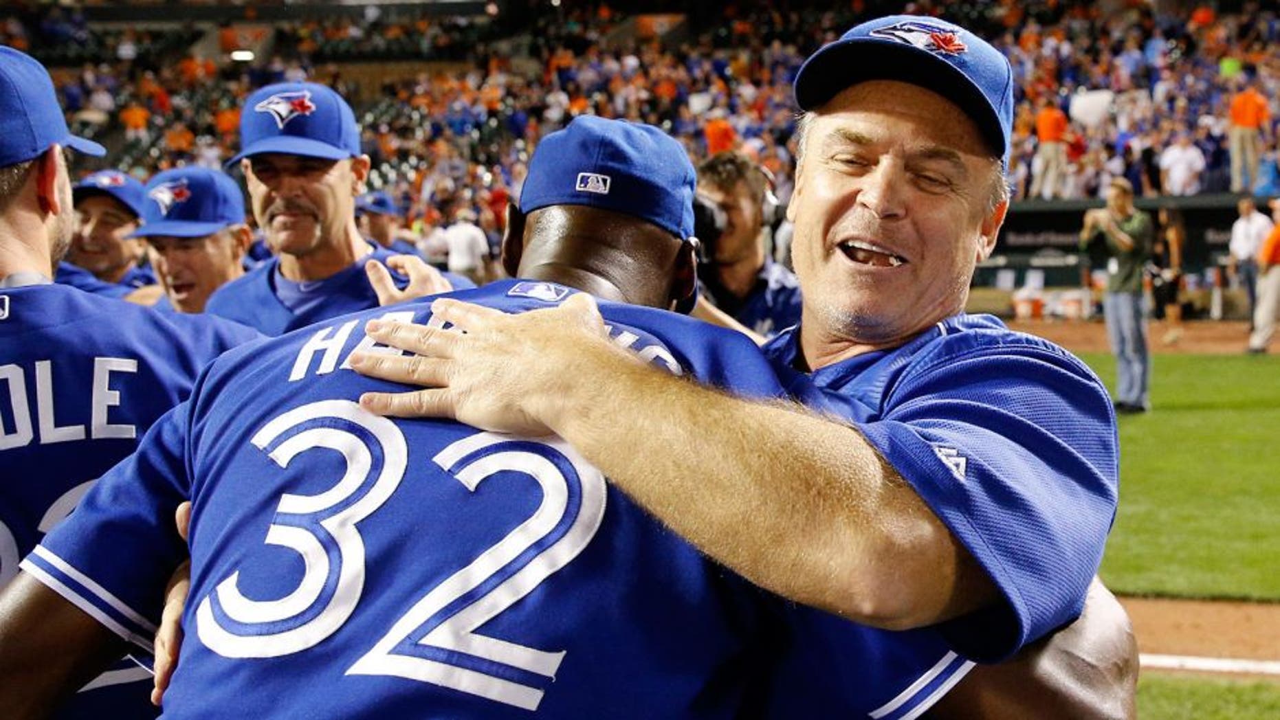 Toronto Blue Jays manager John Gibbons, right, celebrates with relief pitcher LaTroy Hawkins after winning the first baseball game of a doubleheader against the Baltimore Orioles, Wednesday, Sept. 30, 2015, in Baltimore. Toronto won 15-2 to clinch the American League East. (AP Photo/Patrick Semansky)