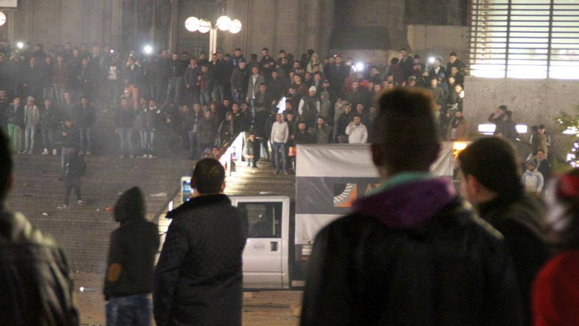 FILE -In this Dec. 31, 2015 file picture, persons gather at the Cologne, Germany, main station. Cologne is planning a hugely increased police presence for New Year's Eve and banning firecrackers around its landmark cathedral to prevent a repeat of last year's string of robberies and sexual assaults.The crimes, blamed largely on foreign men, heightened tensions in Germany over the influx of migrants in 2015. Current police chief Juergen Mathies said Monday Dec. 12, 2016 more than 1,500 officers will be on duty in Cologne this New Year's Eve, compared with around 140 last time. Video surveillance is being stepped up. (Markus Boehm/dpa via AP, file)