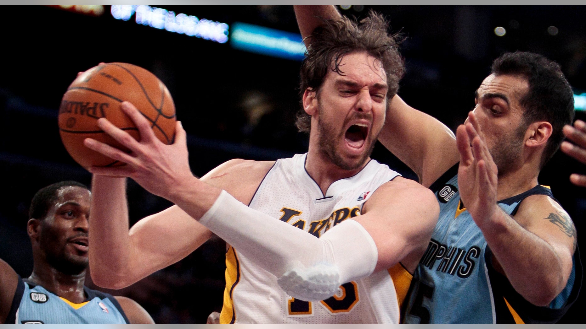 Los Angeles Lakers forward Pau Gasol, middle, grabs a rebound from Memphis Grizzlies center Hamed Haddadi, right, as Grizzlies guard Jeremy Pargo, left, looks on during the second half of an NBA basketball game, Sunday, March 25, 2012, in Los Angeles. The Grizzlies won 102-96. (AP Photo/Bret Hartman)