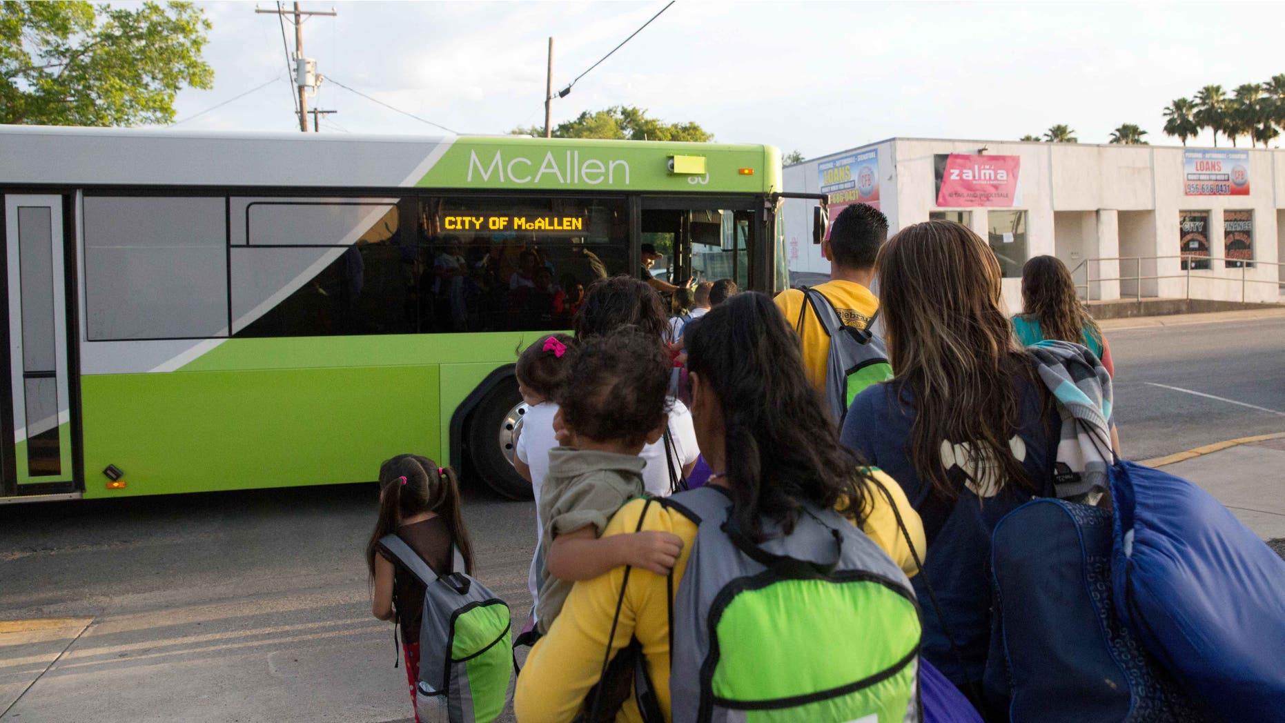 Immigrant families board a bus headed to the downtown bus station in McAllen, Texas on April 30, 2015.