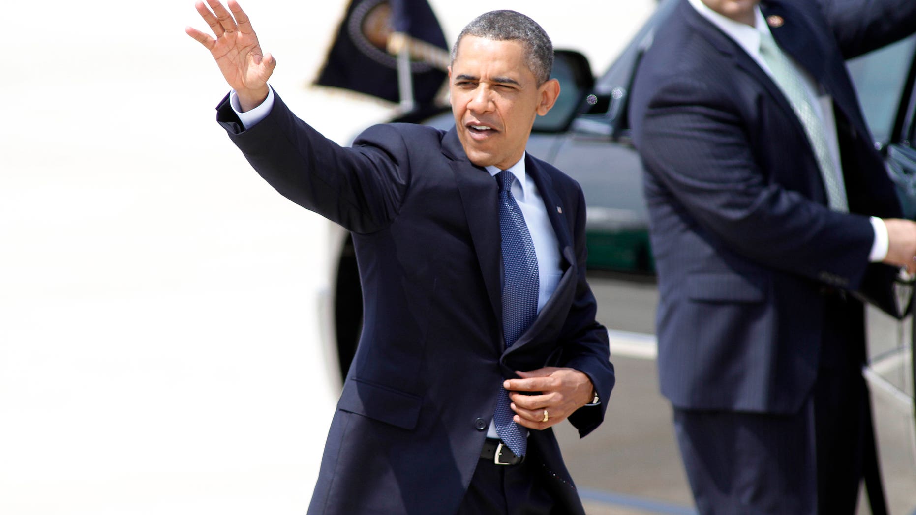 President Barack Obama waves to spectators after arriving at Raleigh Durham International Airport in Morrisville, N.C., Monday, June 13, 2011. (AP Photo/Jim R. Bounds)
