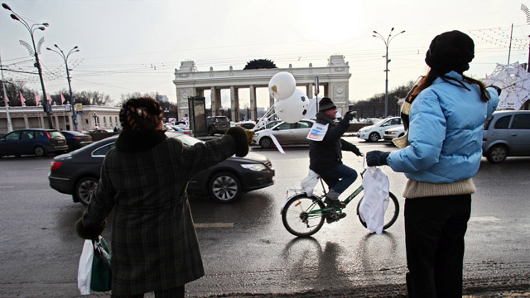 Feb. 19: People standing on a sidewalk wave in support to the participants of the motorist's rally in Moscow.