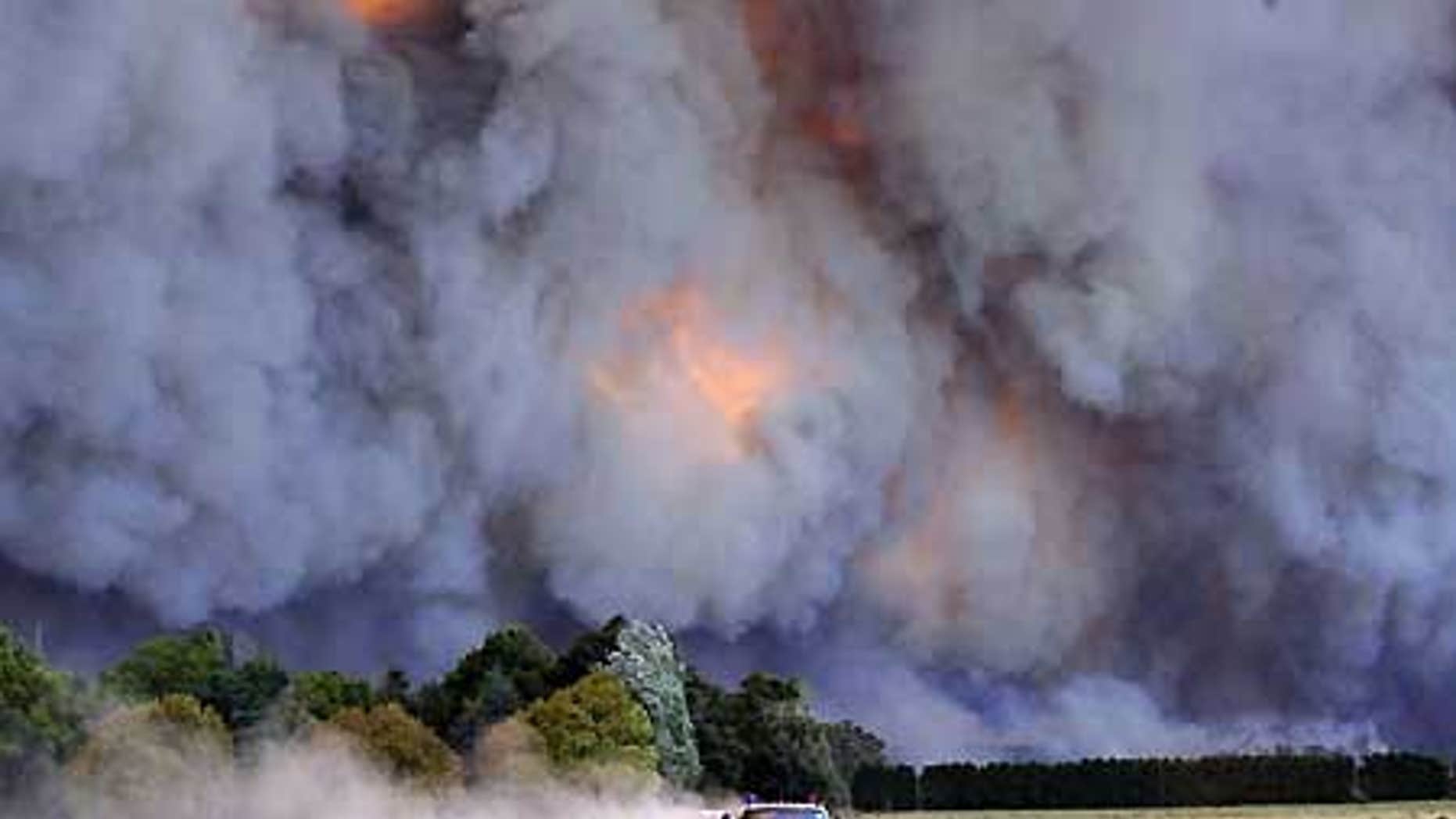 Feb. 7: An emergency vehicle races away from a blaze near a structure in the Gippsland region in Australia's Victoria state.