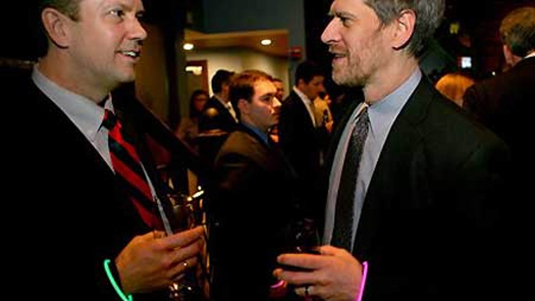 Feb. 4: Phil Berent of New York, right, with a pink bracelet indicating he is looking for work, speaks with recruiter Kevin Johnson.