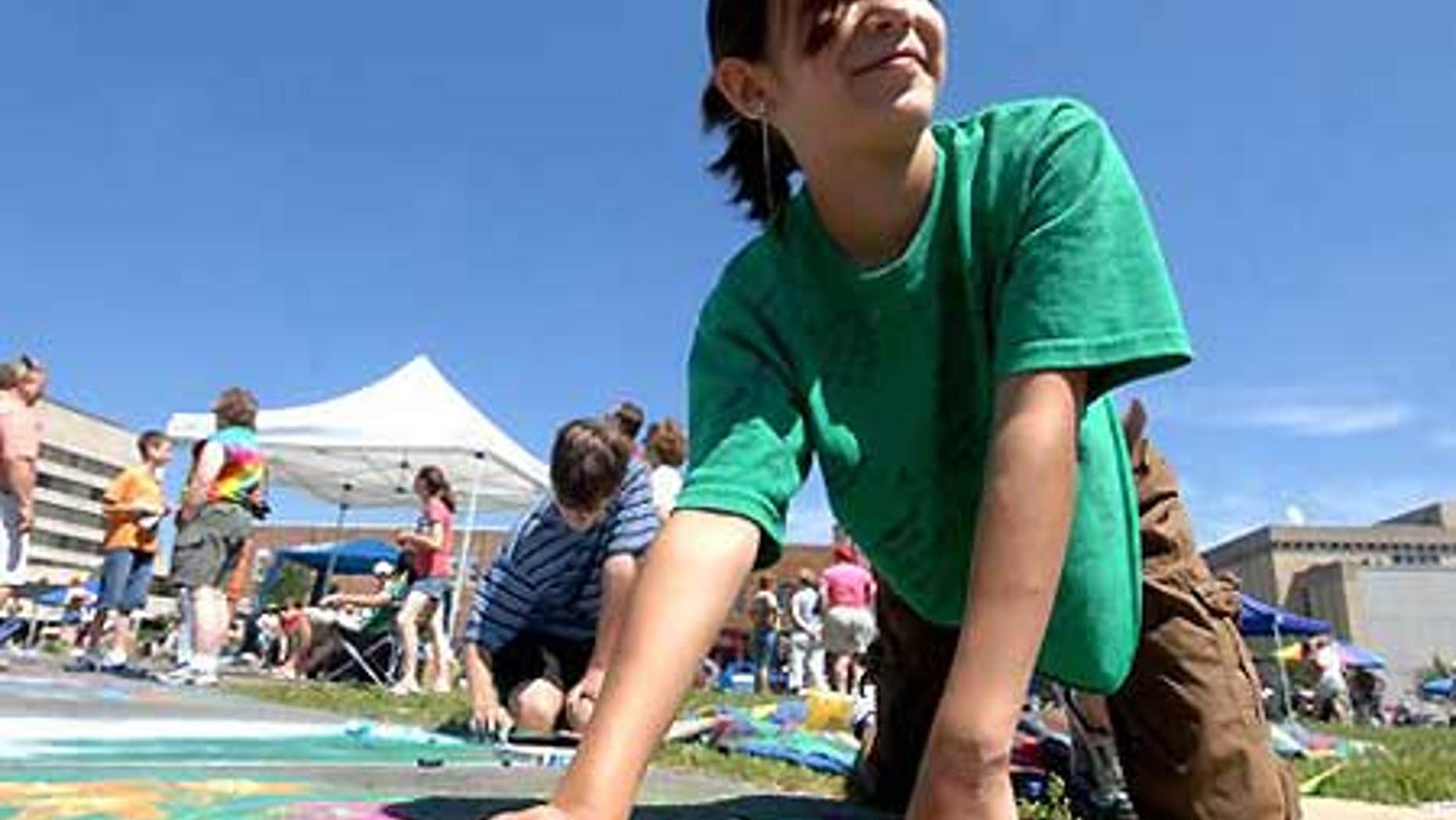 Madeline Kara Neumann works on chalk art during downtown Wausau's annual Chalk Fest.