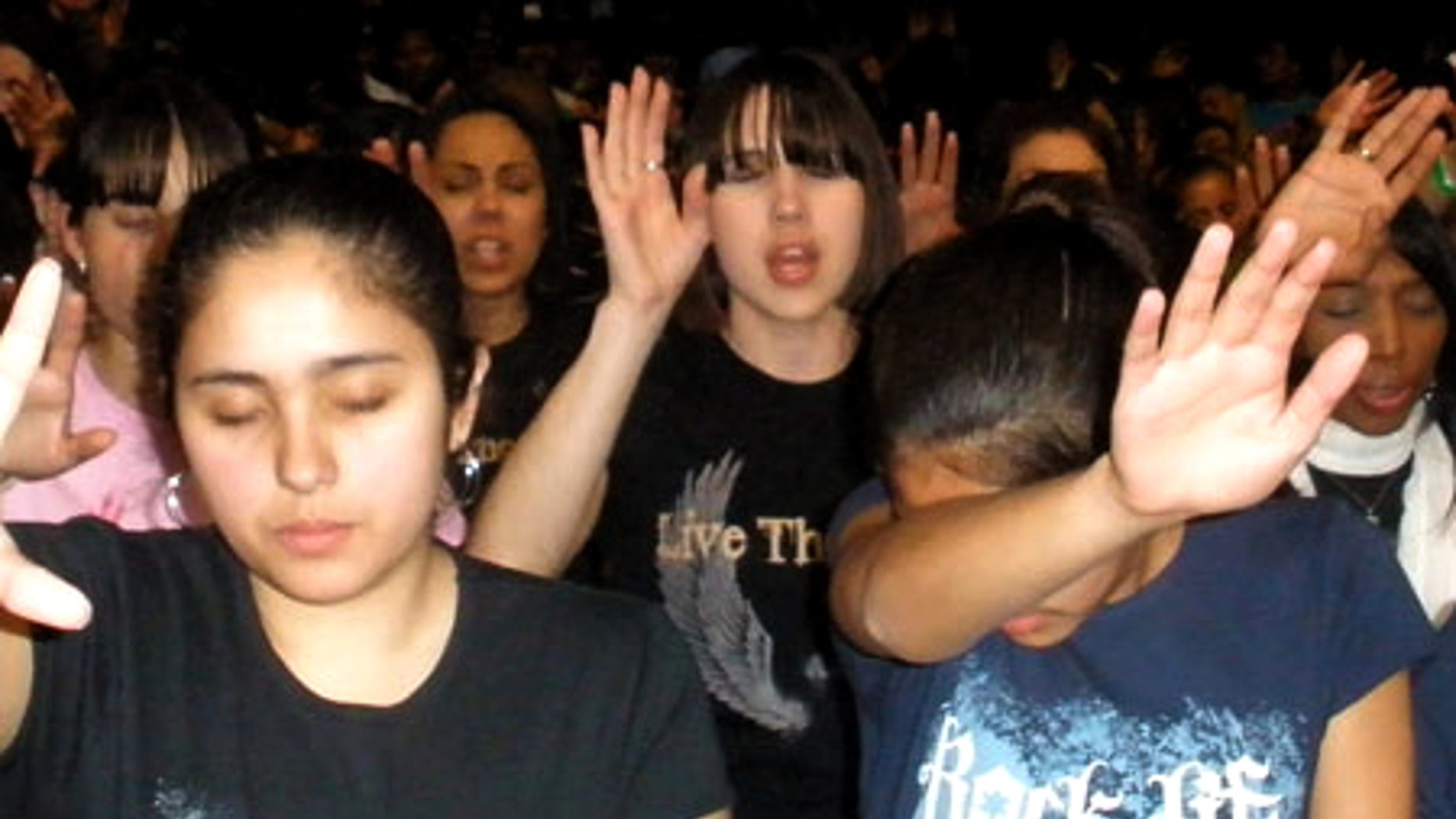 April 18: Concertgoers reach their hands up in prayer during a moment of worship at at the IZOD Center in New Jersey.