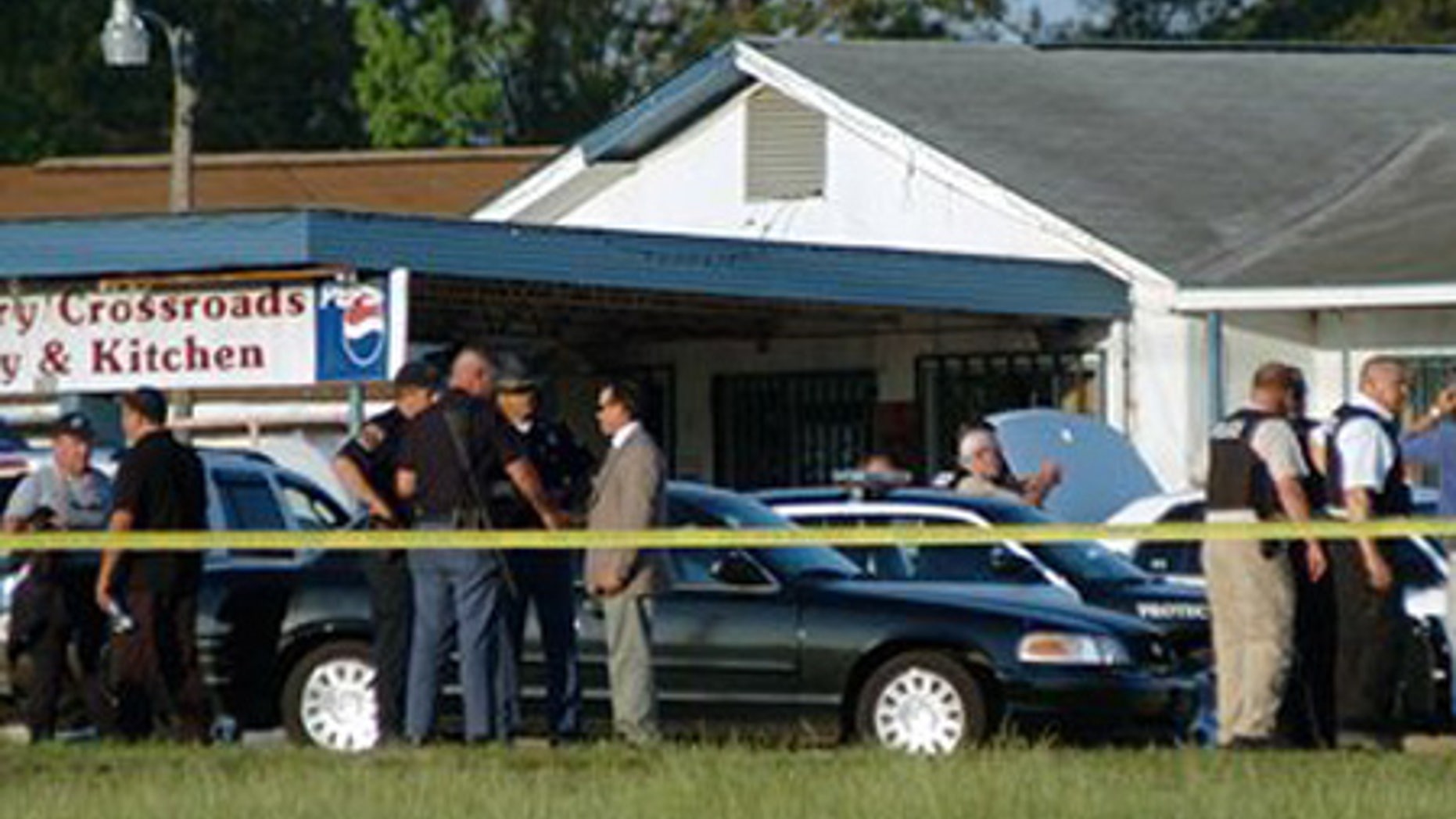 April 24: Law enforcement personnel and first responders work the scene of a shooting that left one police officer and the suspect dead in Alabama.