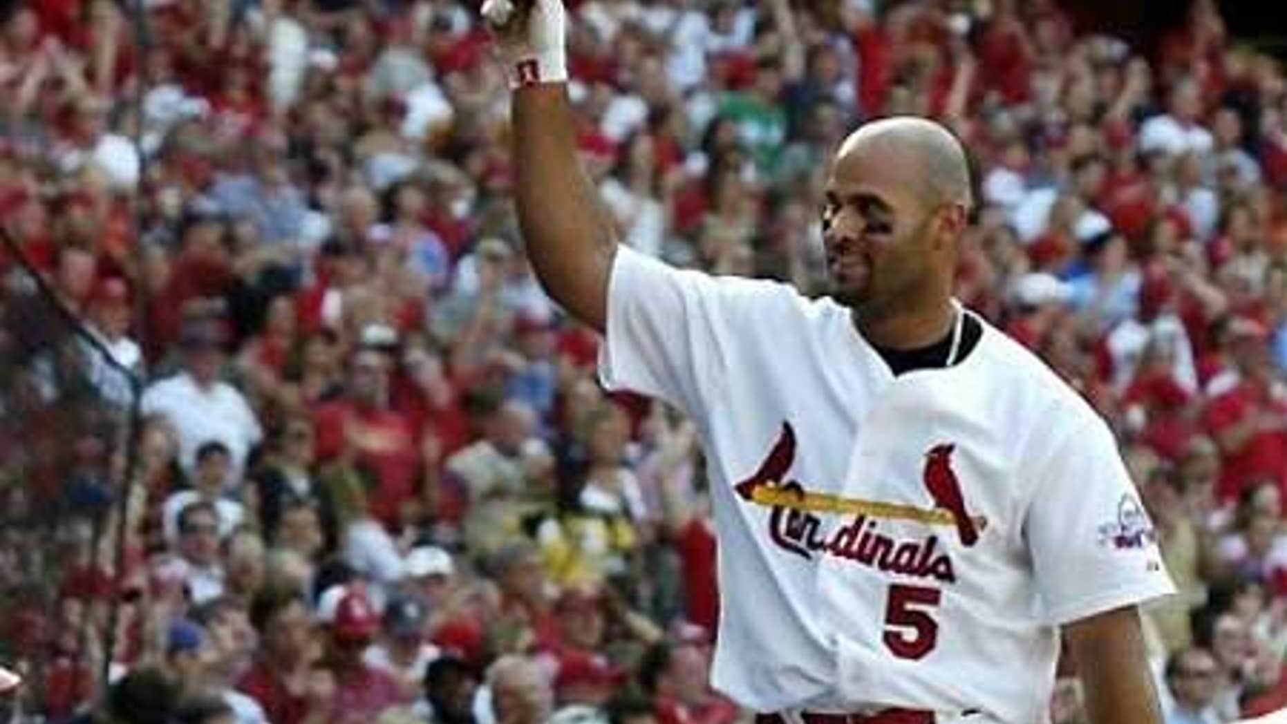 April 25: Albert Pujols tips his helmet to the crowd after hitting a seventh-inning grand slam against the Cubs.