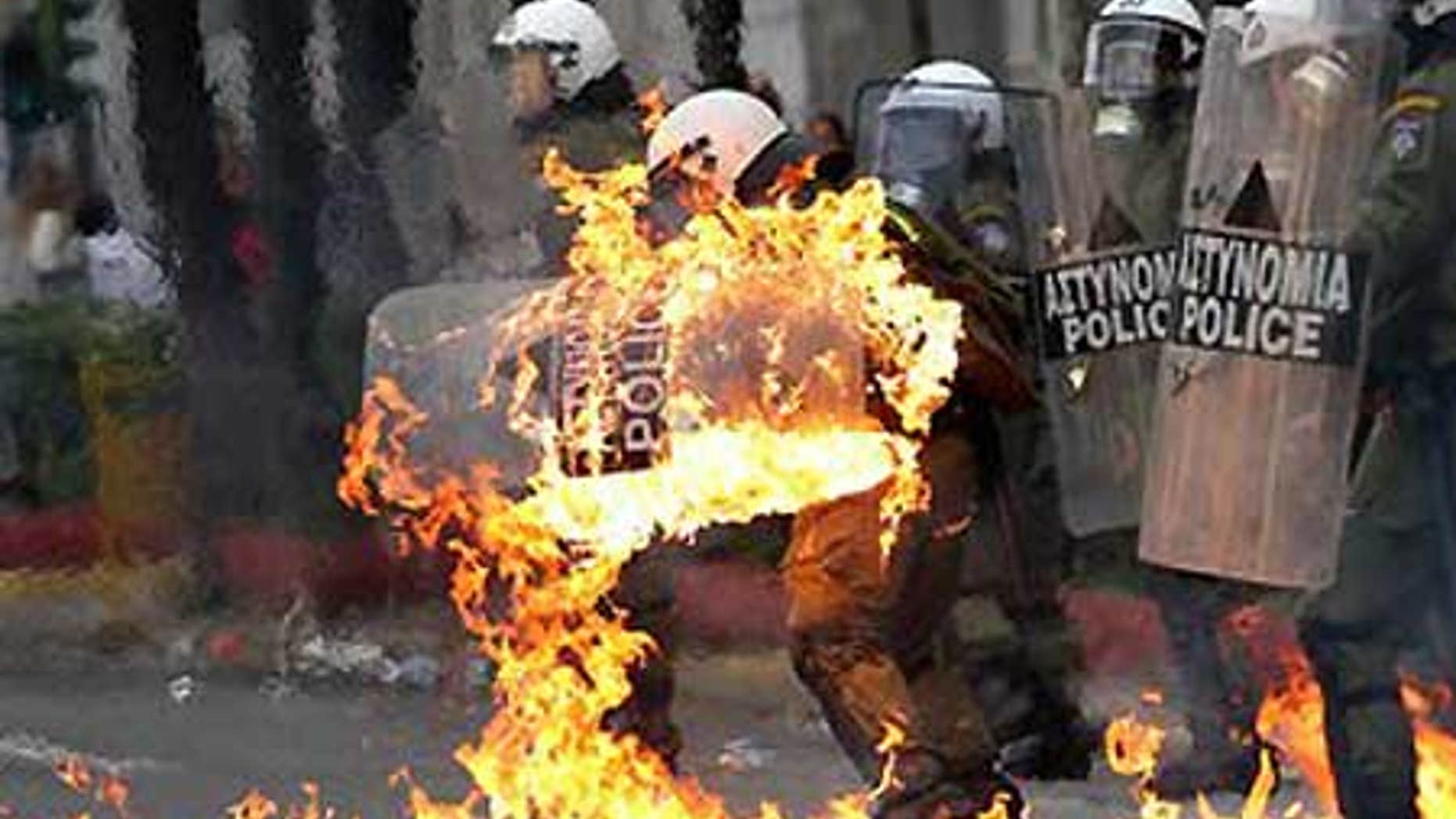 Dec. 6: A riot policeman's clothing catches fire after demonstrators threw petrol bombs at them, as violence erupted.