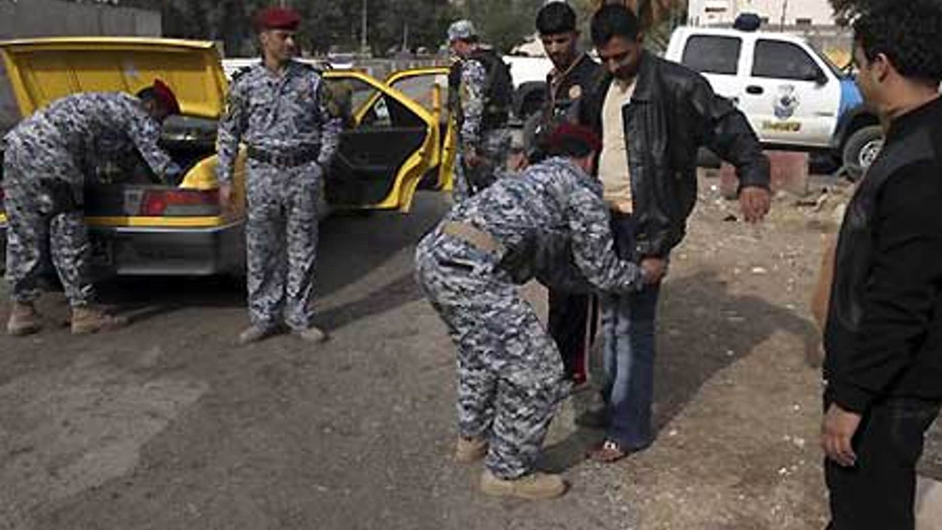 Dec. 14: Iraqi policemen search a man and his car at checkpoint in central Baghdad, Iraq.