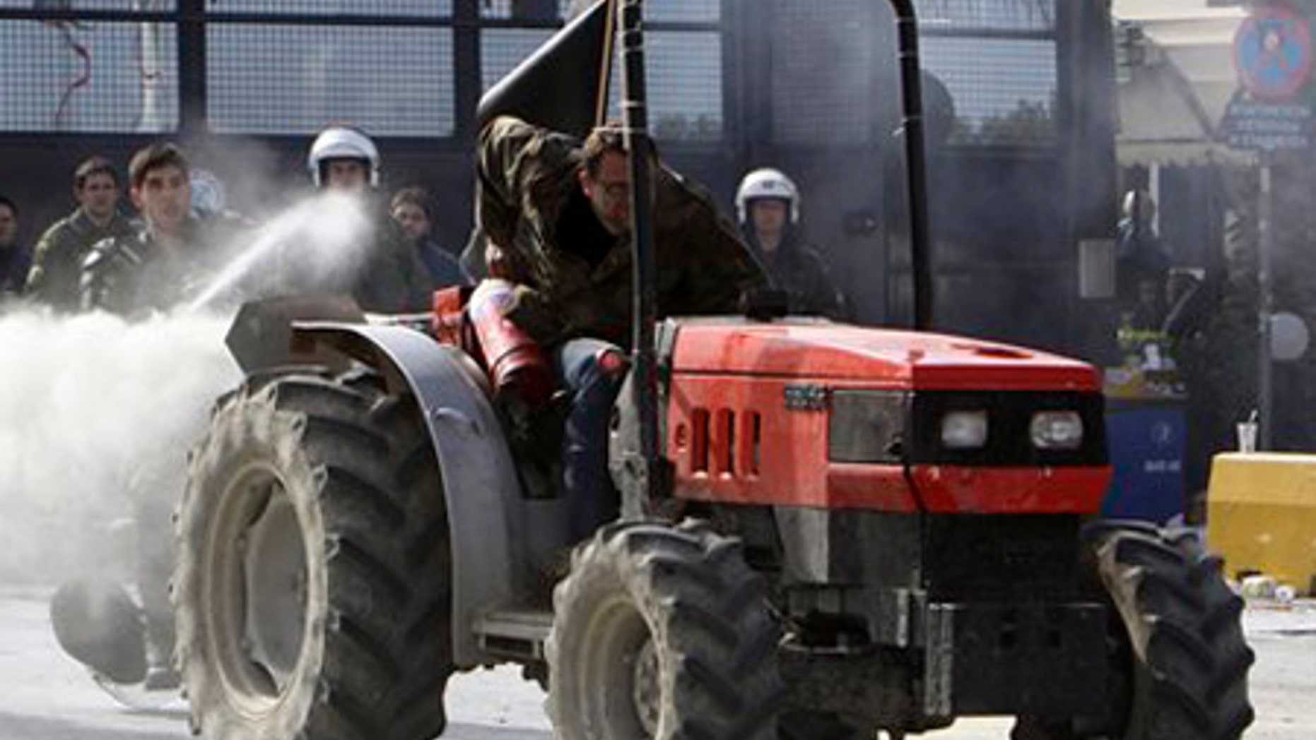 Feb. 3: A farmer riding a tractor uses a fire extinguisher against riot police, as a police officer responds with pepper spray, near Athens, Tuesday.