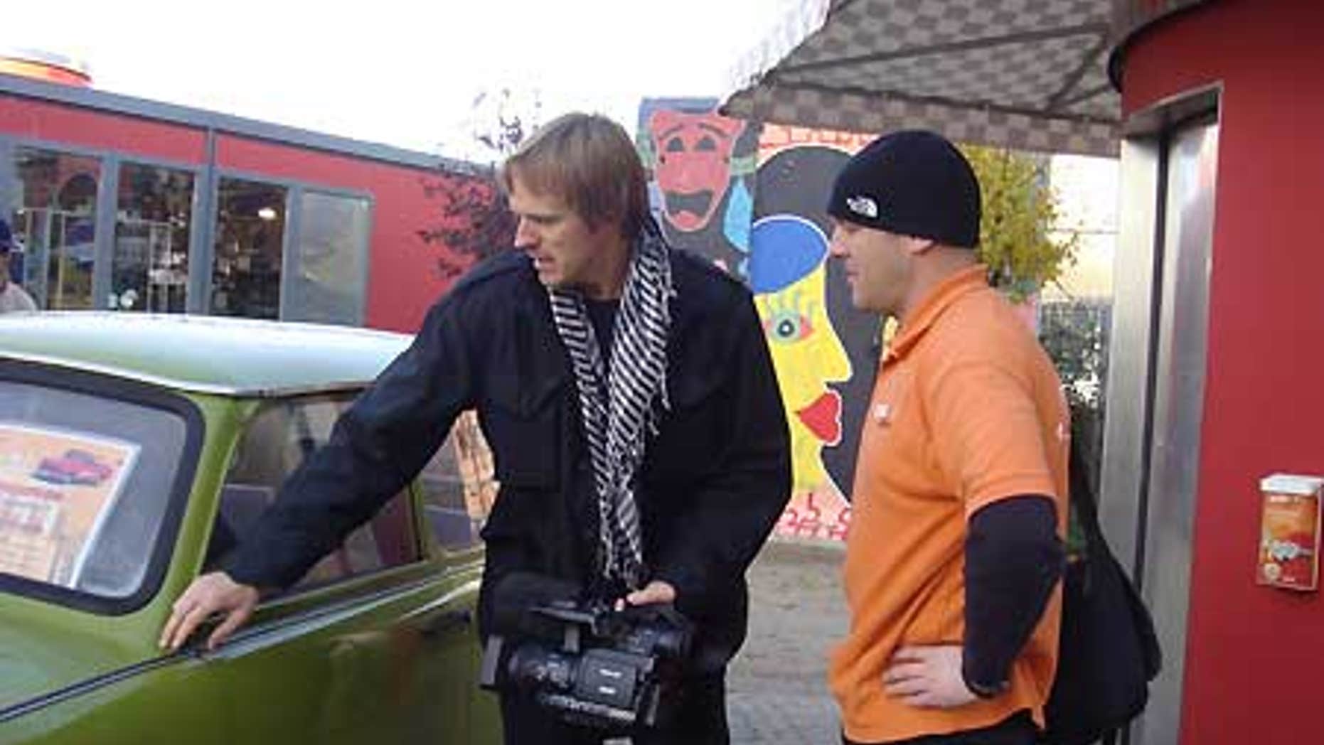 Fox News cameraman, Olaf Wiig, examines an old Trabi.