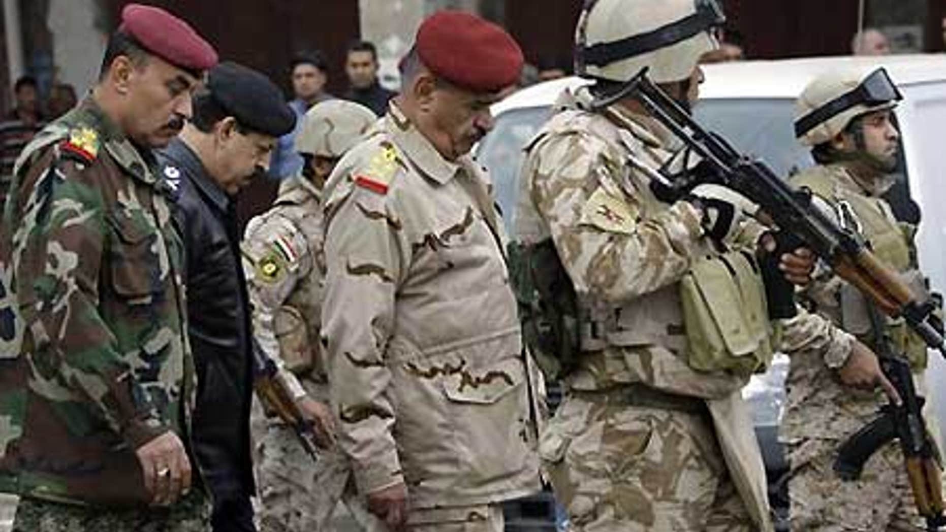 Dec. 8: Gen. Abboud Qanbar, center, escorted by bodyguards, inspects site of a bomb attack near the new Finance Ministry building in Baghdad, Iraq.