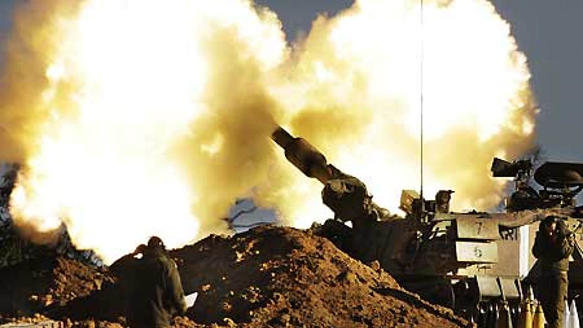 Jan. 6: Israeli Army soldiers take cover as a mobile artillery piece fires towards targets in the southern Gaza Strip.