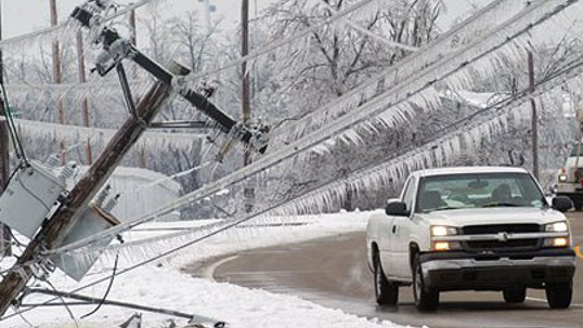 Jan. 31: A vehicle prepares to pass the top of a power pole that fell onto the sidewalk along 3rd Street in Paducah, Ky.